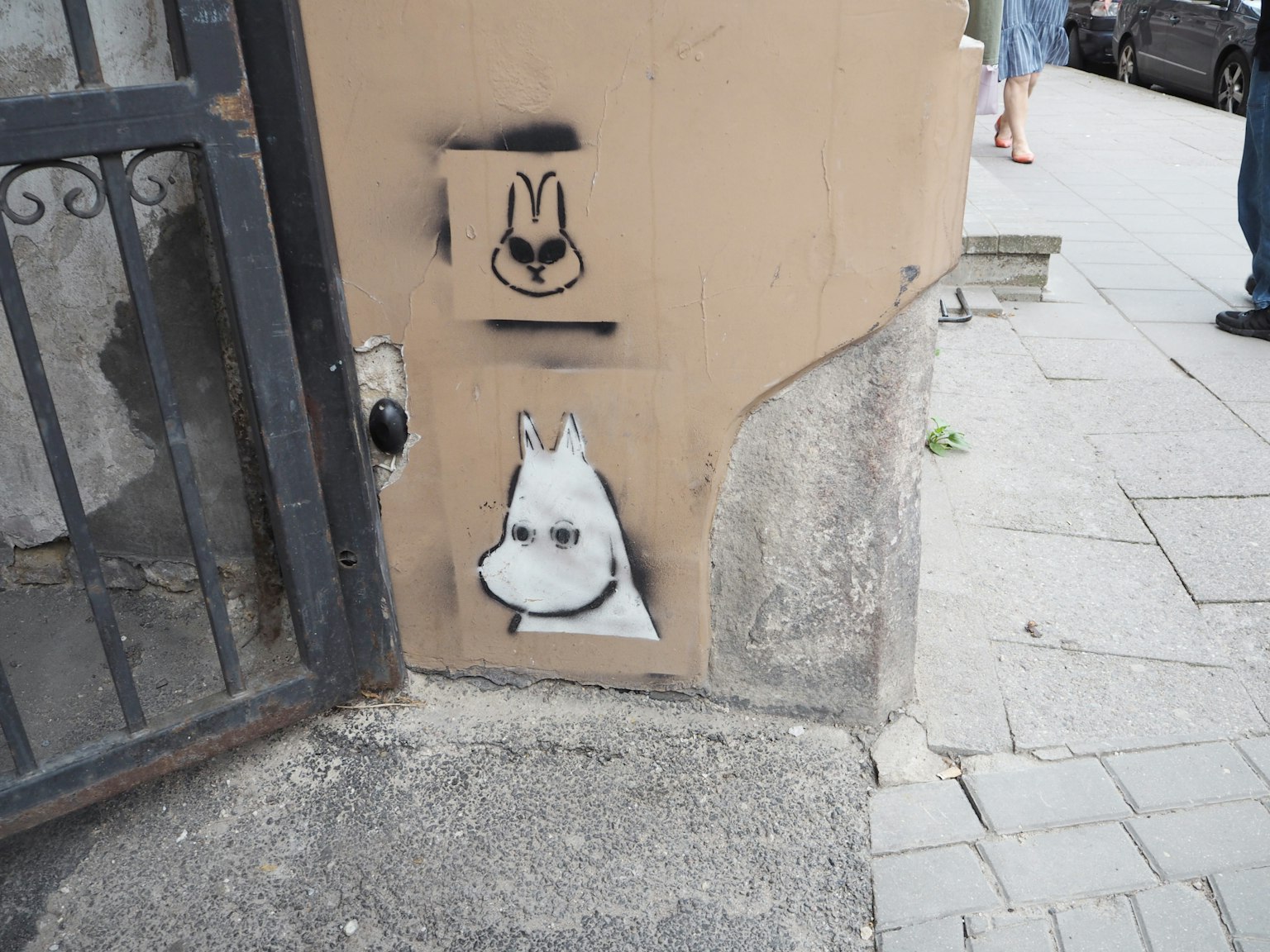 Art de rue représentant un visage de chien et un visage de lapin sur un mur
