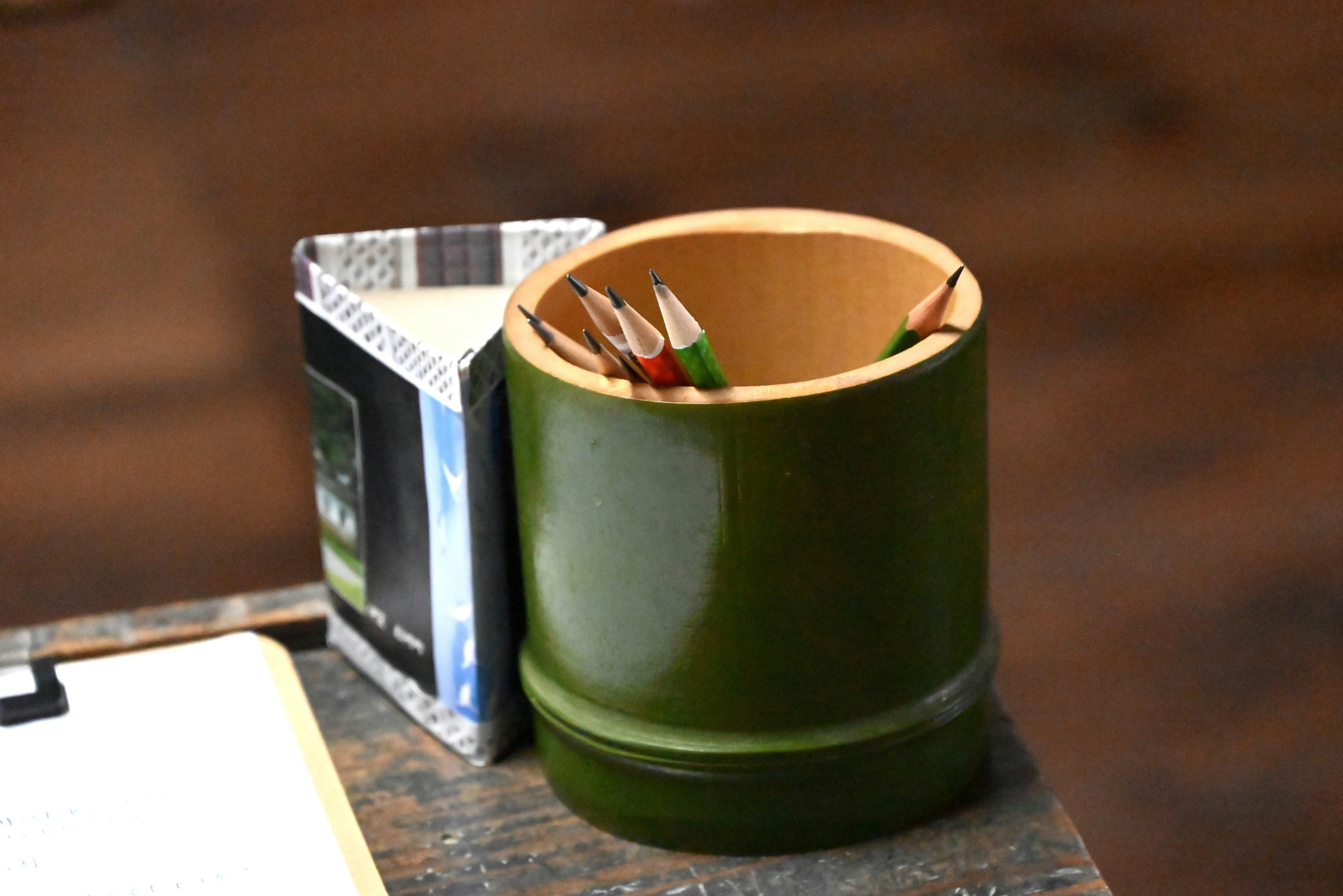 green bamboo pencil case with pencils on a desk
