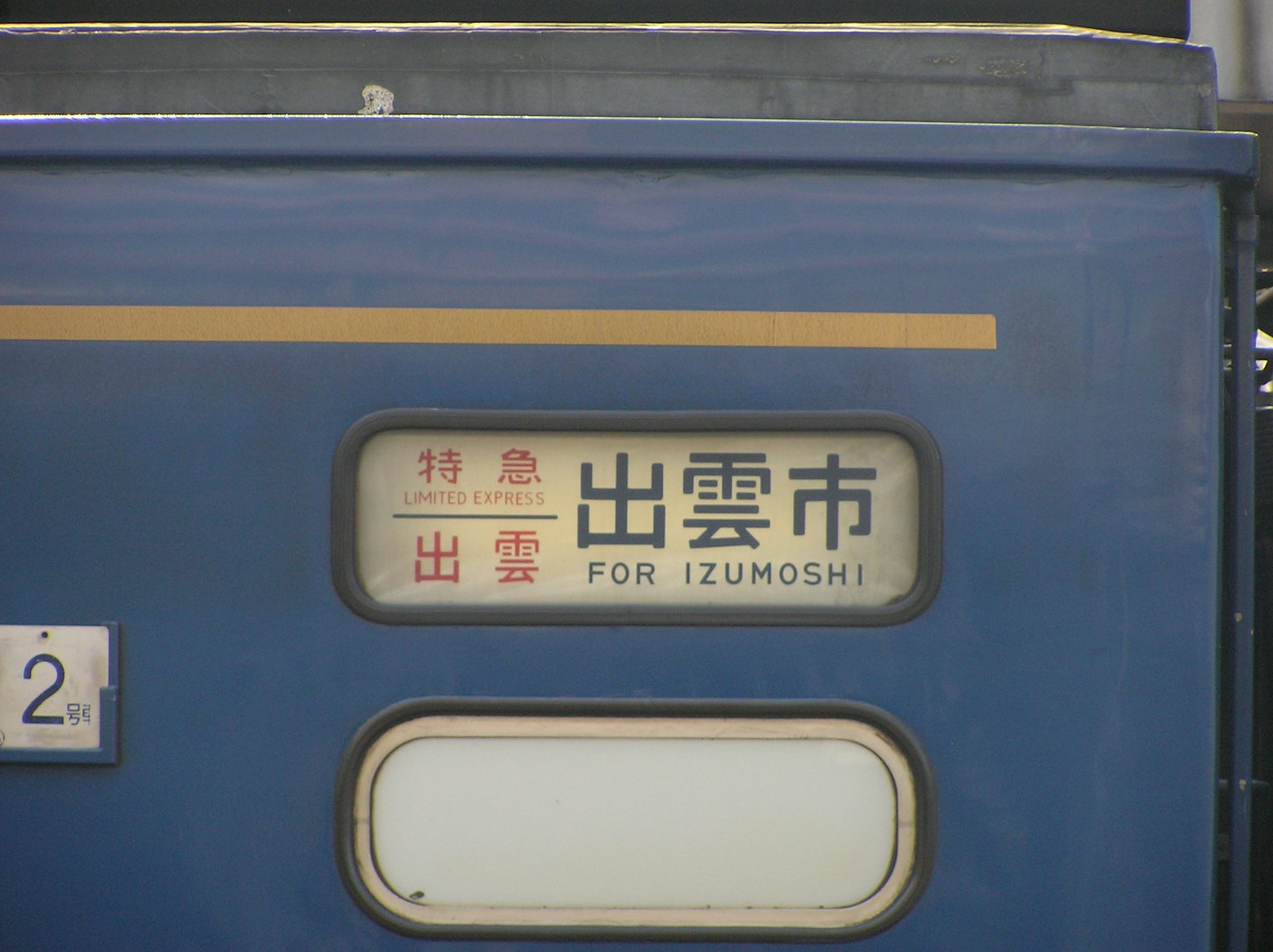 Lato di un treno blu con la destinazione Izumo City