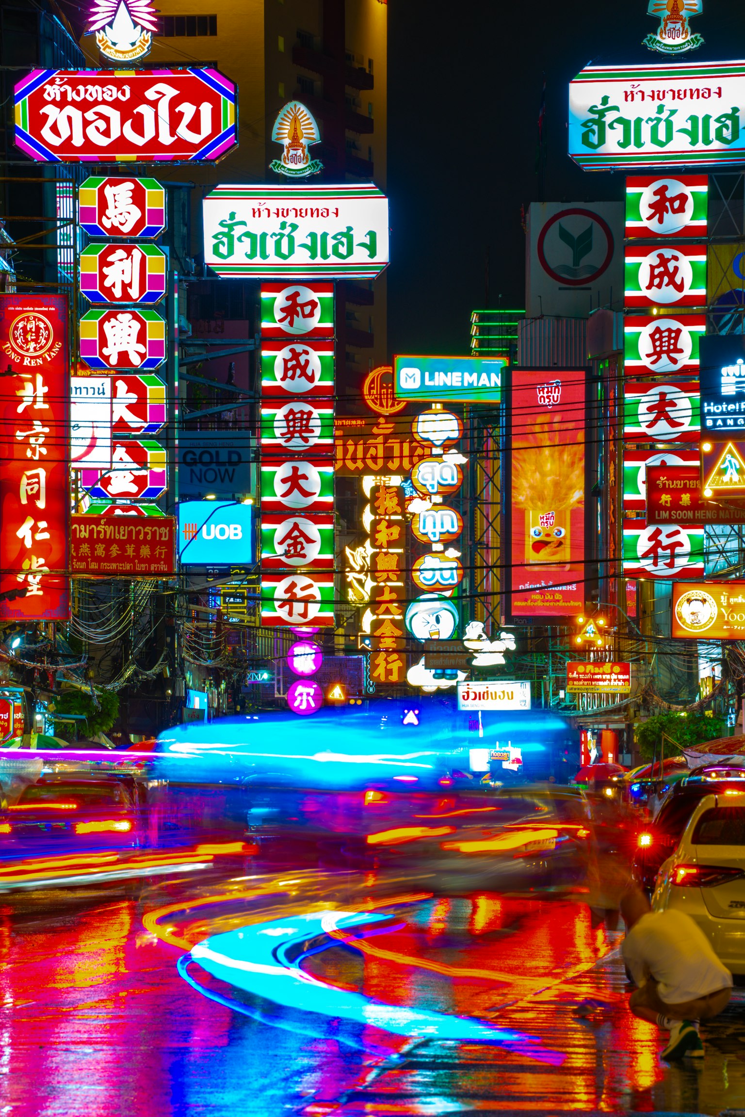 Insegne al neon vibranti e luci delle auto nella vivace strada di Bangkok di notte