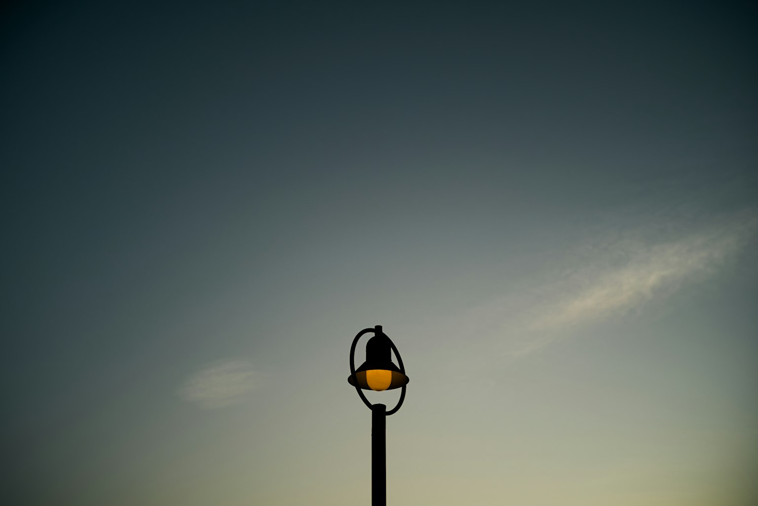 Silhouette of a street lamp against a twilight sky