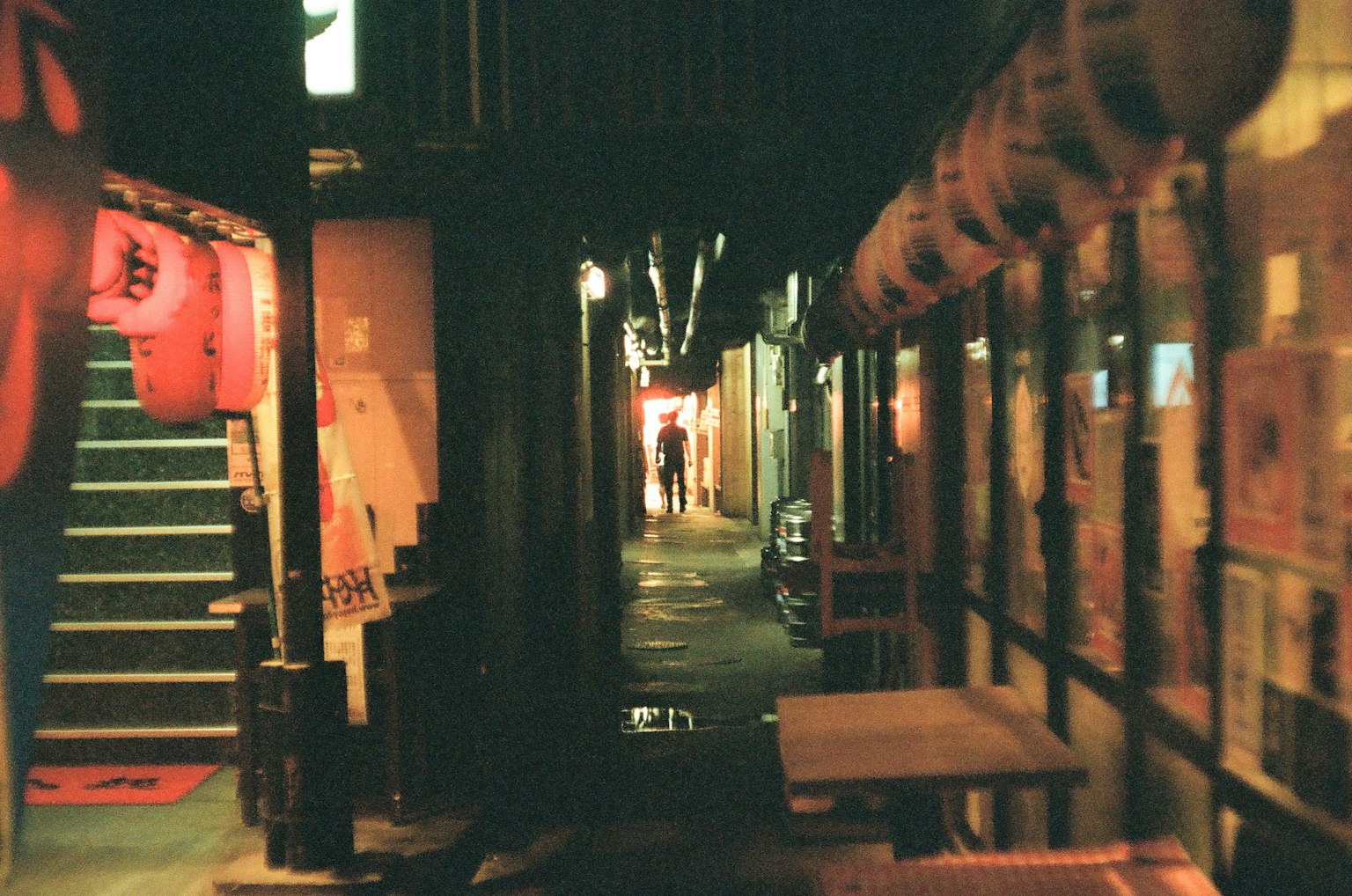 Dimly lit alley featuring lanterns and stairs in a nighttime setting