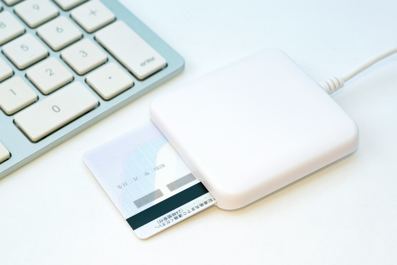 Lecteur de carte blanc à côté d'une carte de crédit près d'un clavier