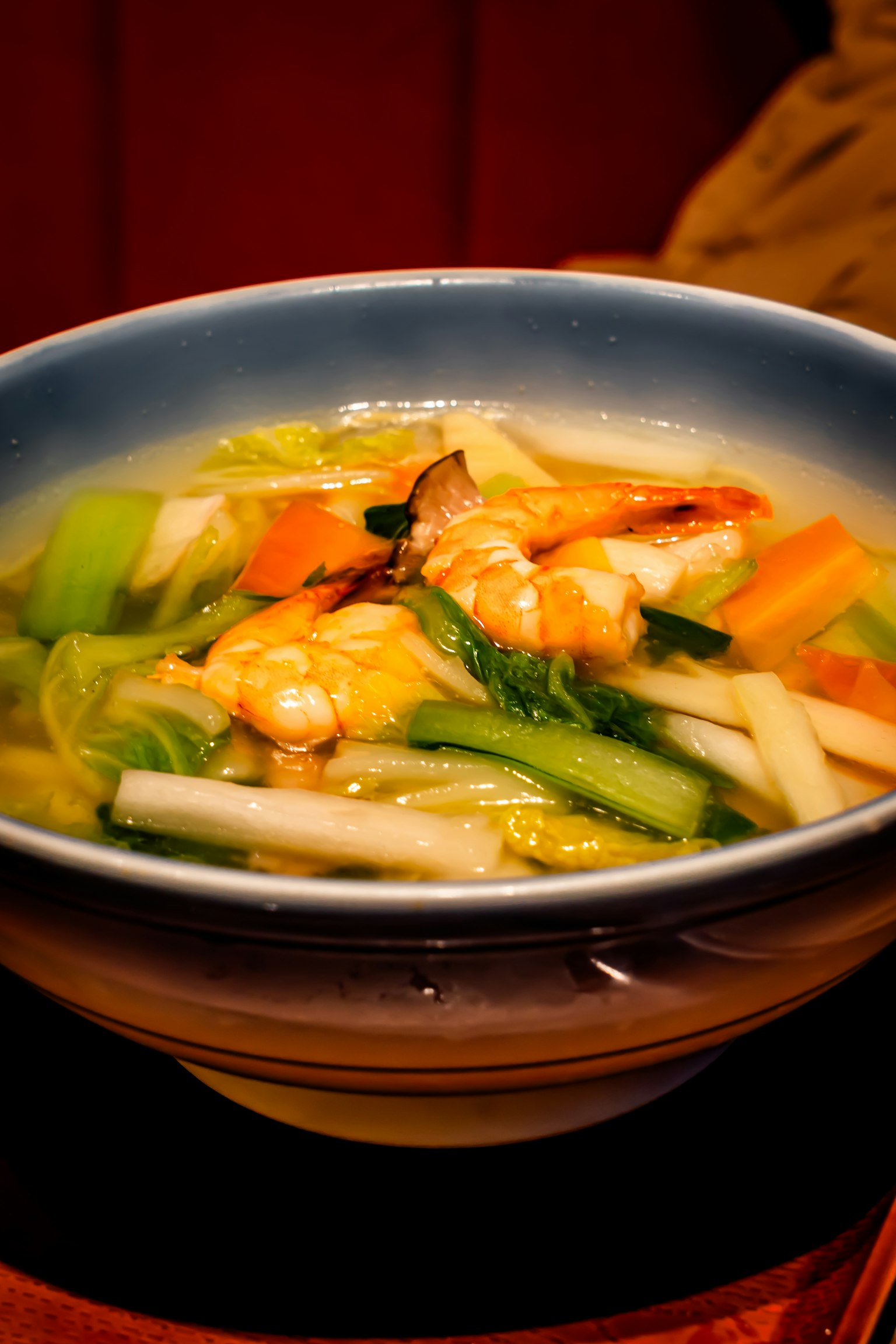Un bol de soupe aux crevettes et légumes aux couleurs vives