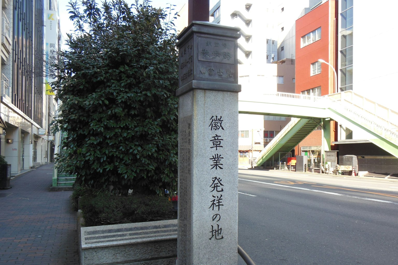 街角的石碑旁边有绿植和建筑物