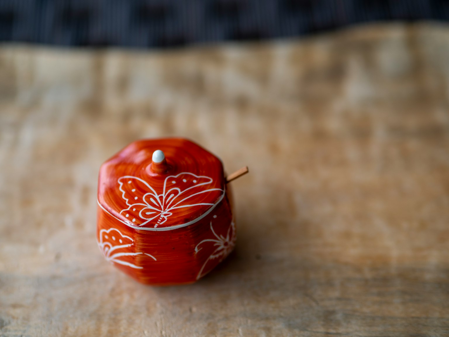 Beau petit récipient japonais rouge avec des motifs de papillon