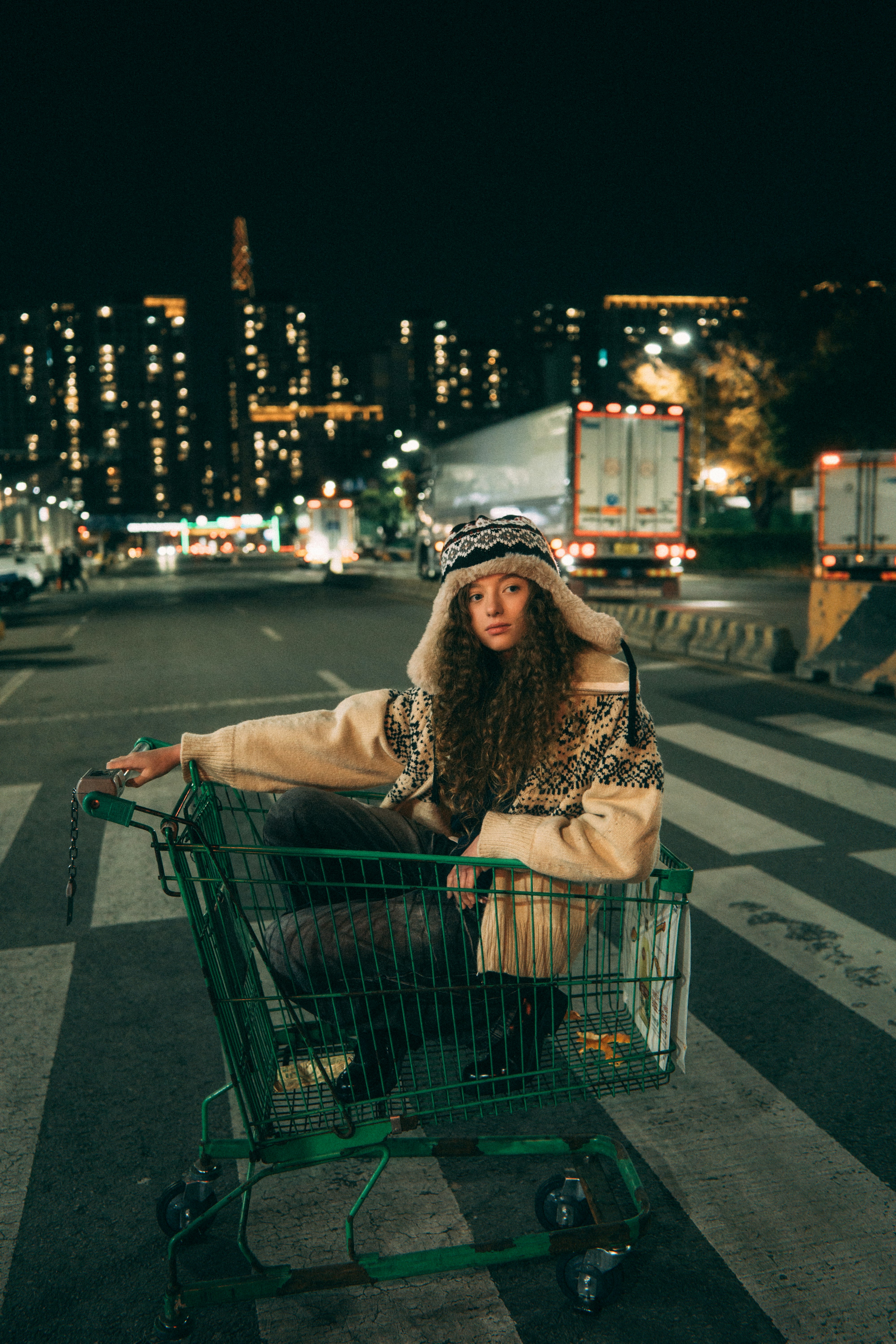 woman pushing a shopping cart on a night city street