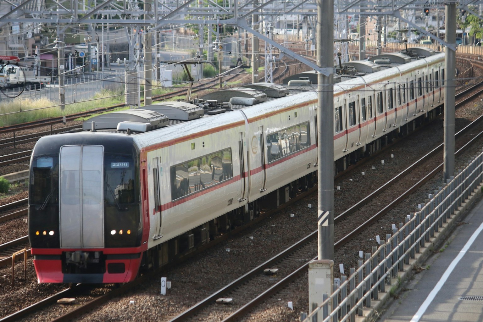 Train moderne avec des rayures rouges circulant sur des voies ferrées