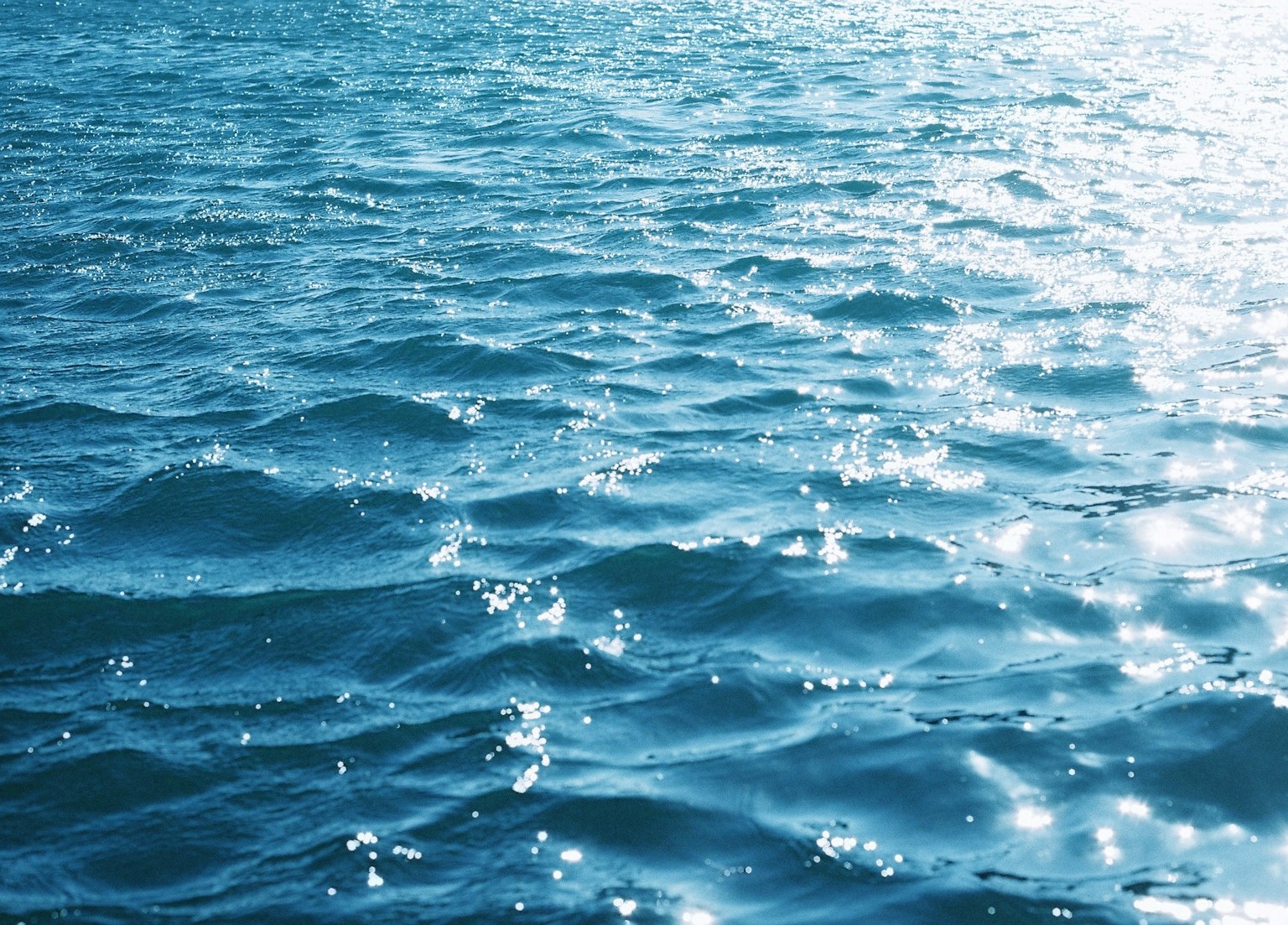 Acqua blu dell'oceano increspata con riflessi scintillanti