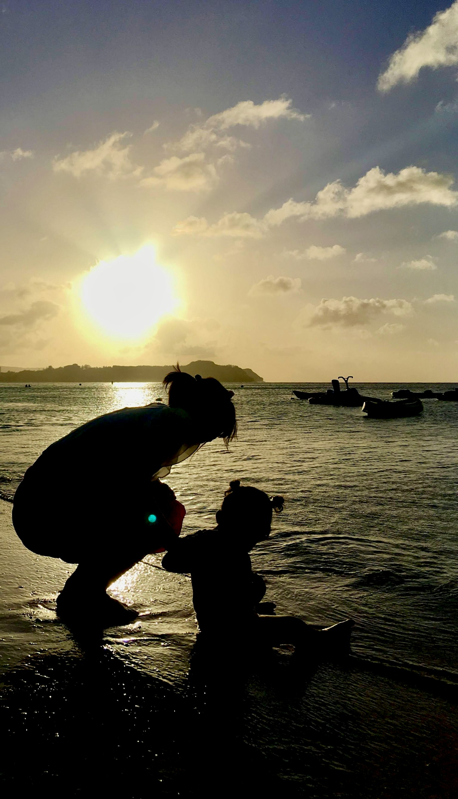Silueta de un padre y un hijo jugando en el mar al atardecer