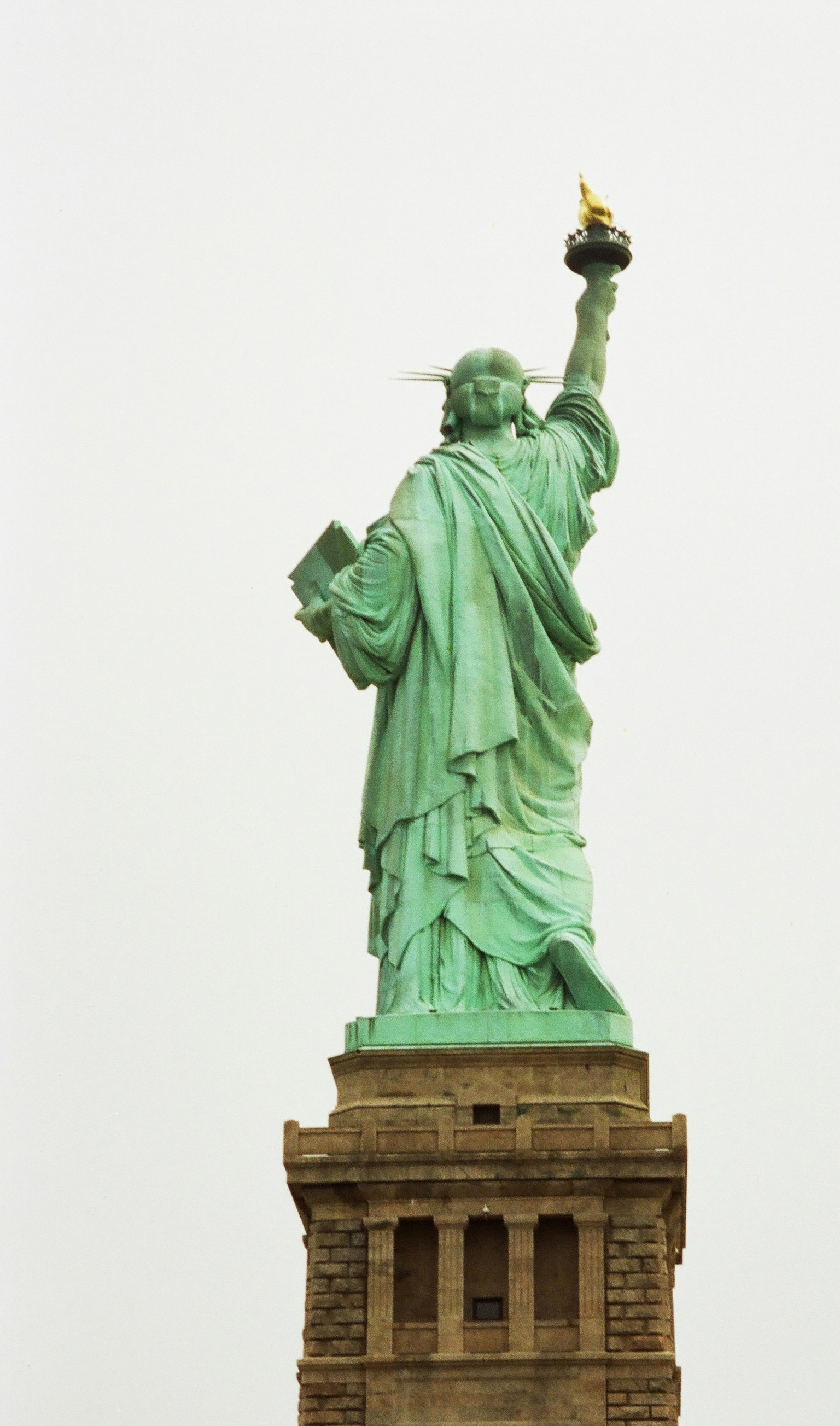 Rückansicht der Freiheitsstatue, die eine Fackel in grünem Patina hält