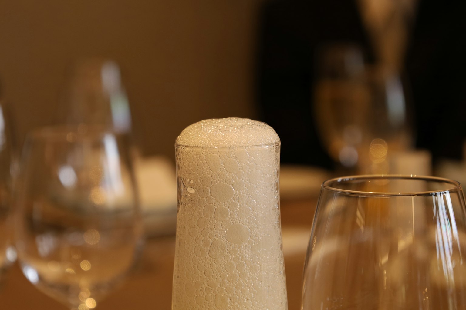 泡沫饮料瓶与餐桌上的酒杯