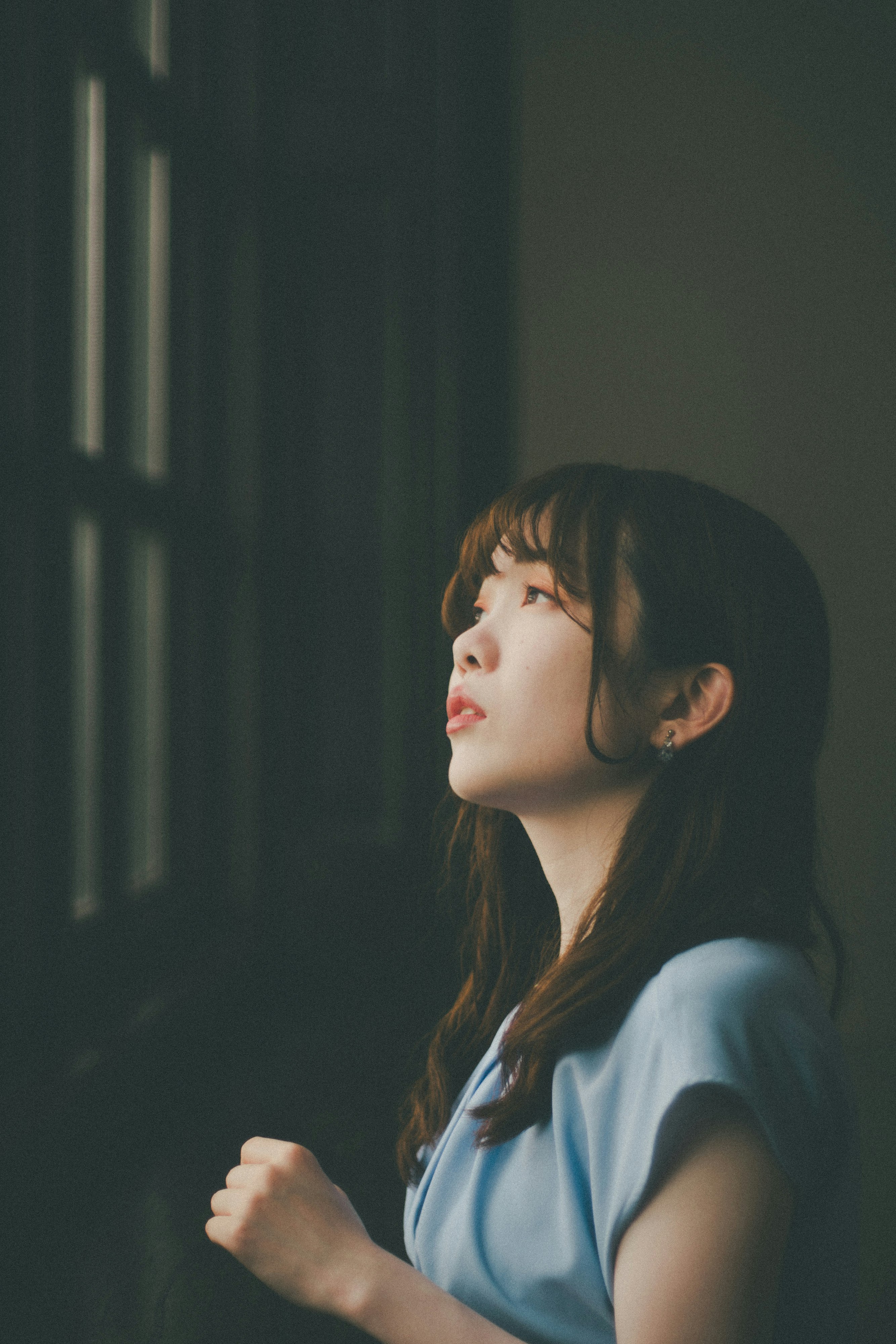窗邊側臉抬頭的女性