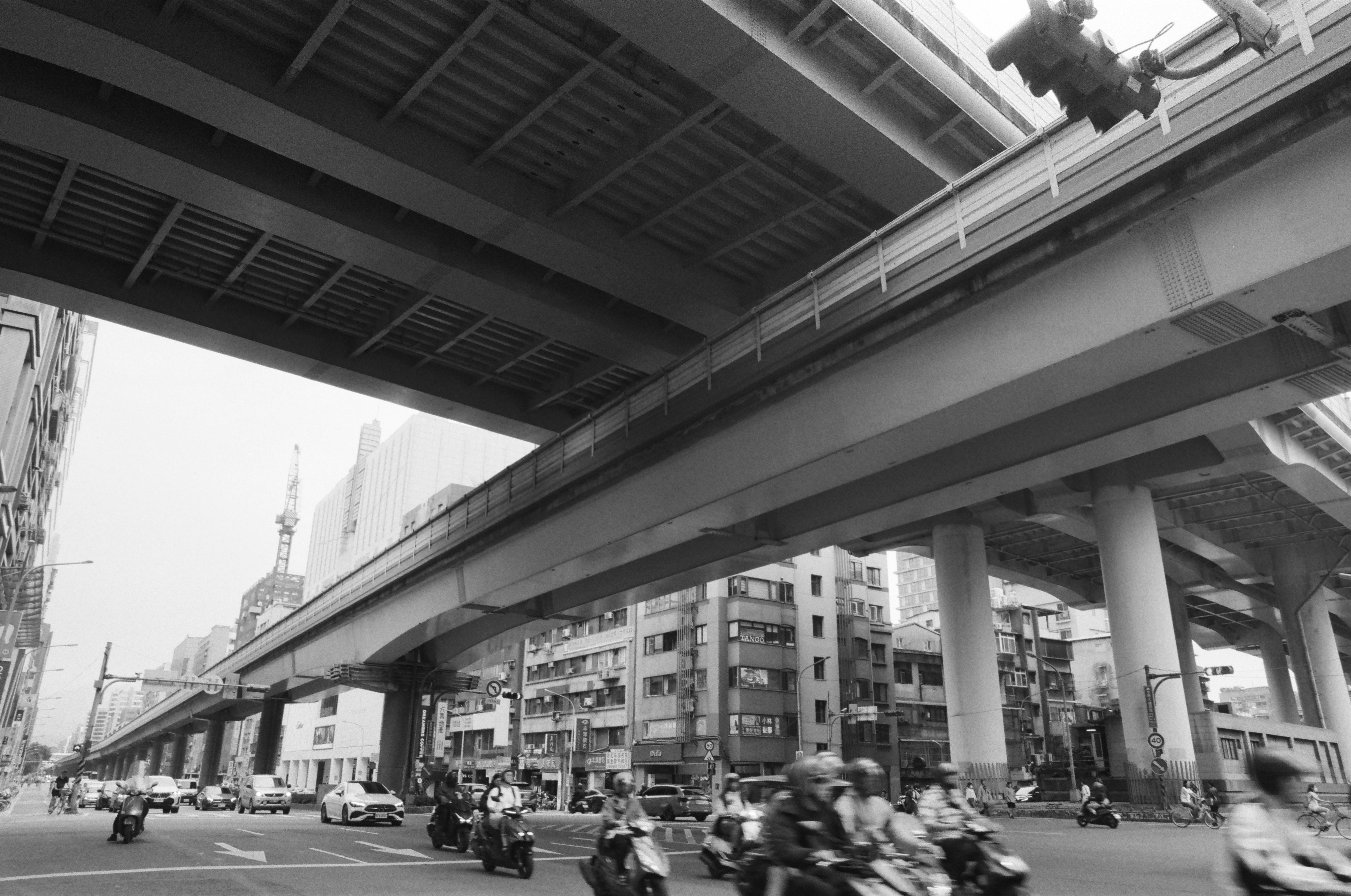 高架の高架橋と車道を走るバイクのある都市の通り