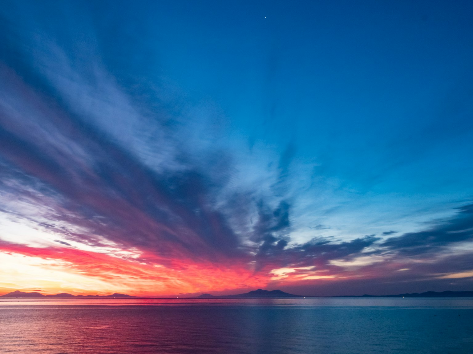 Ciel de coucher de soleil magnifique avec des dégradés de bleu et de rouge sur l'océan