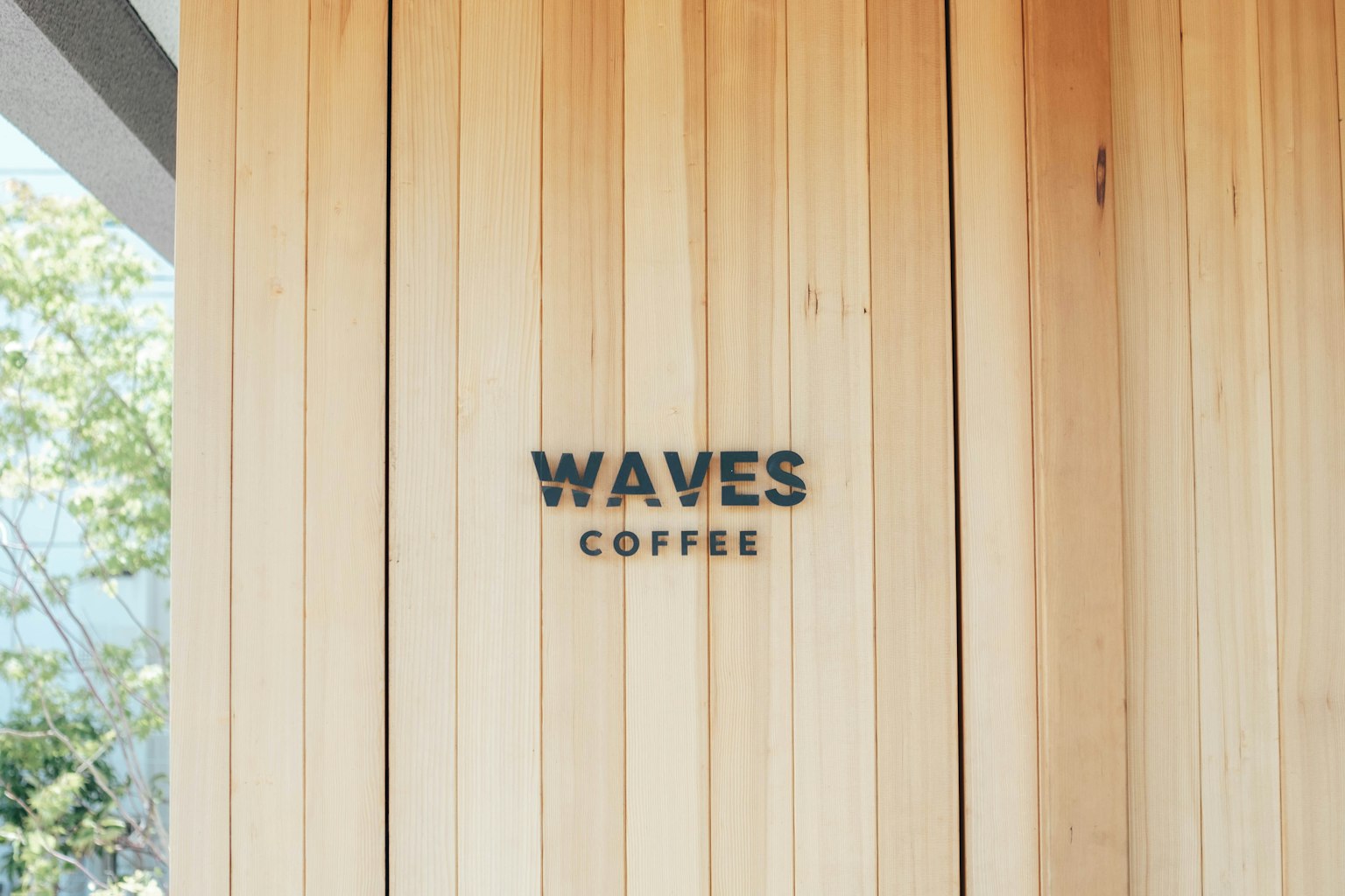 ป้าย WAVES COFFEE บนผนังไม้
