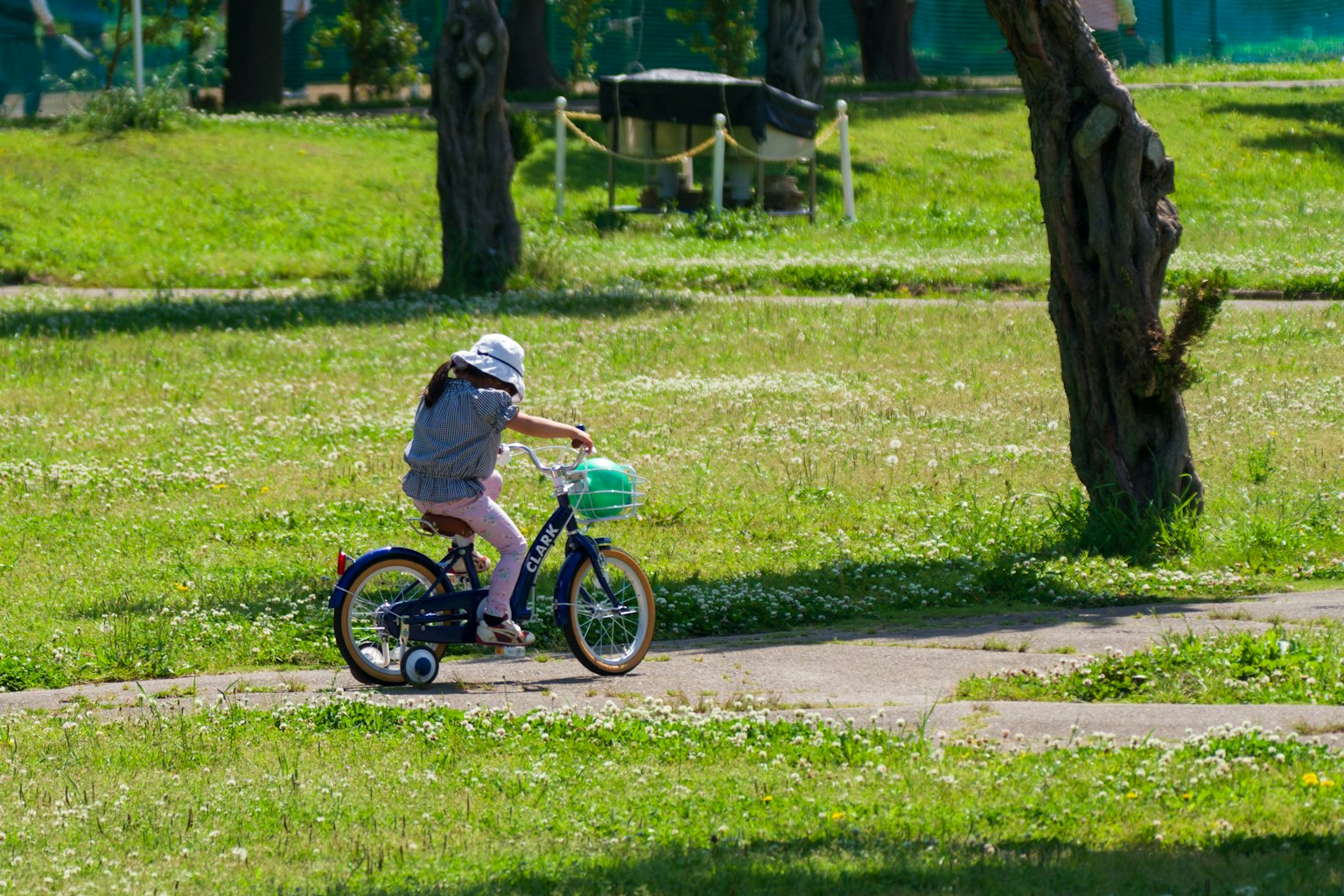 Bambino che pedala in un parco verde