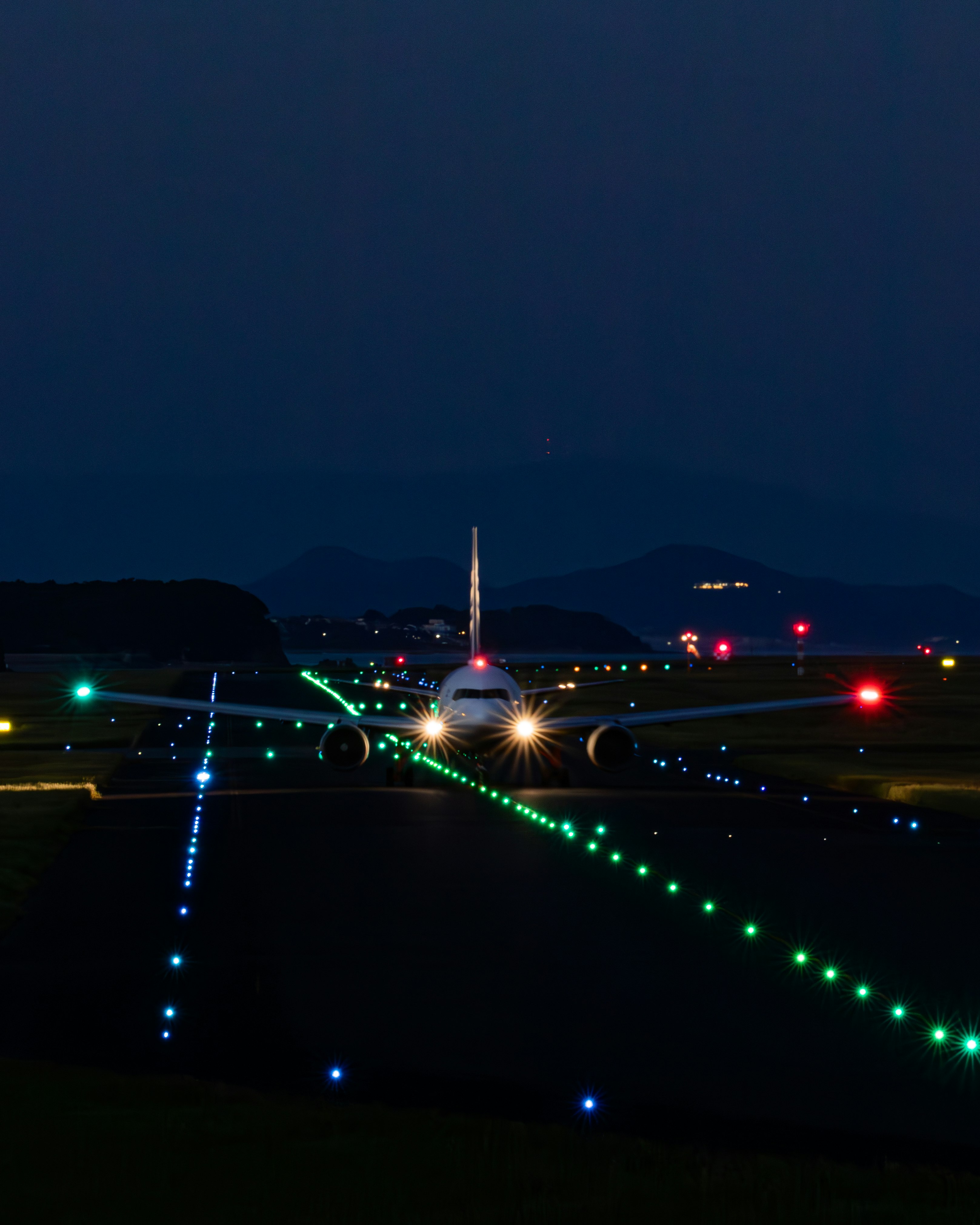 夜間跑道上發光的引導燈與飛機