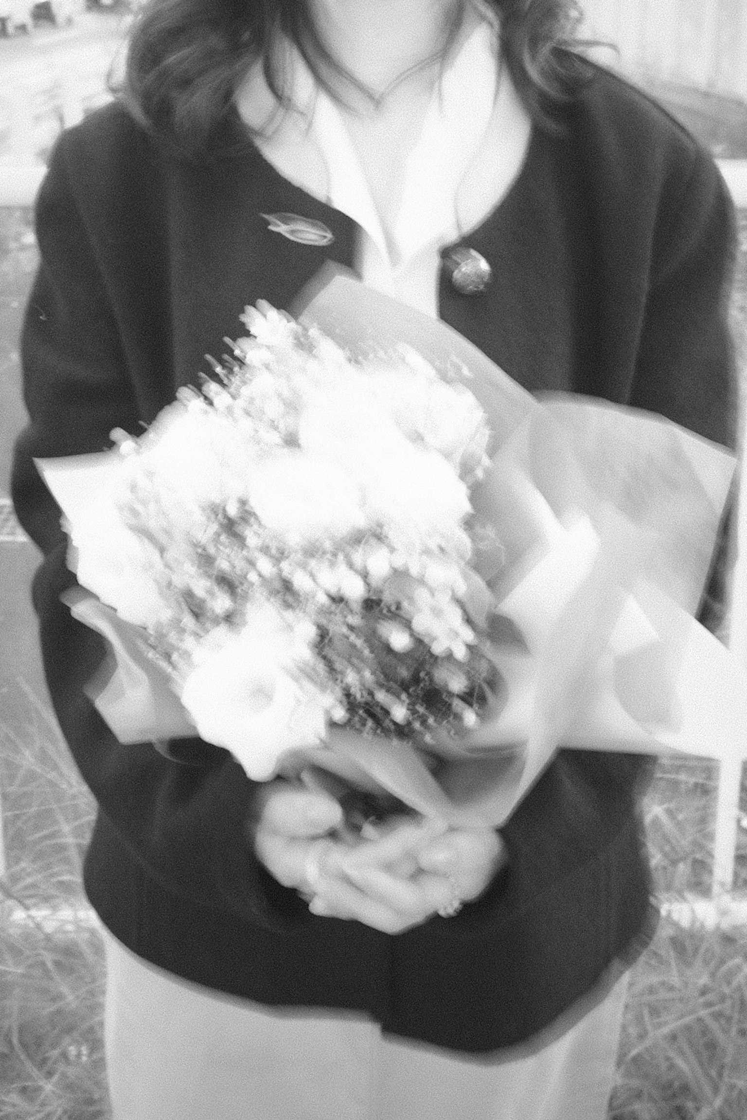 Foto in bianco e nero di una donna che tiene un mazzo di fiori