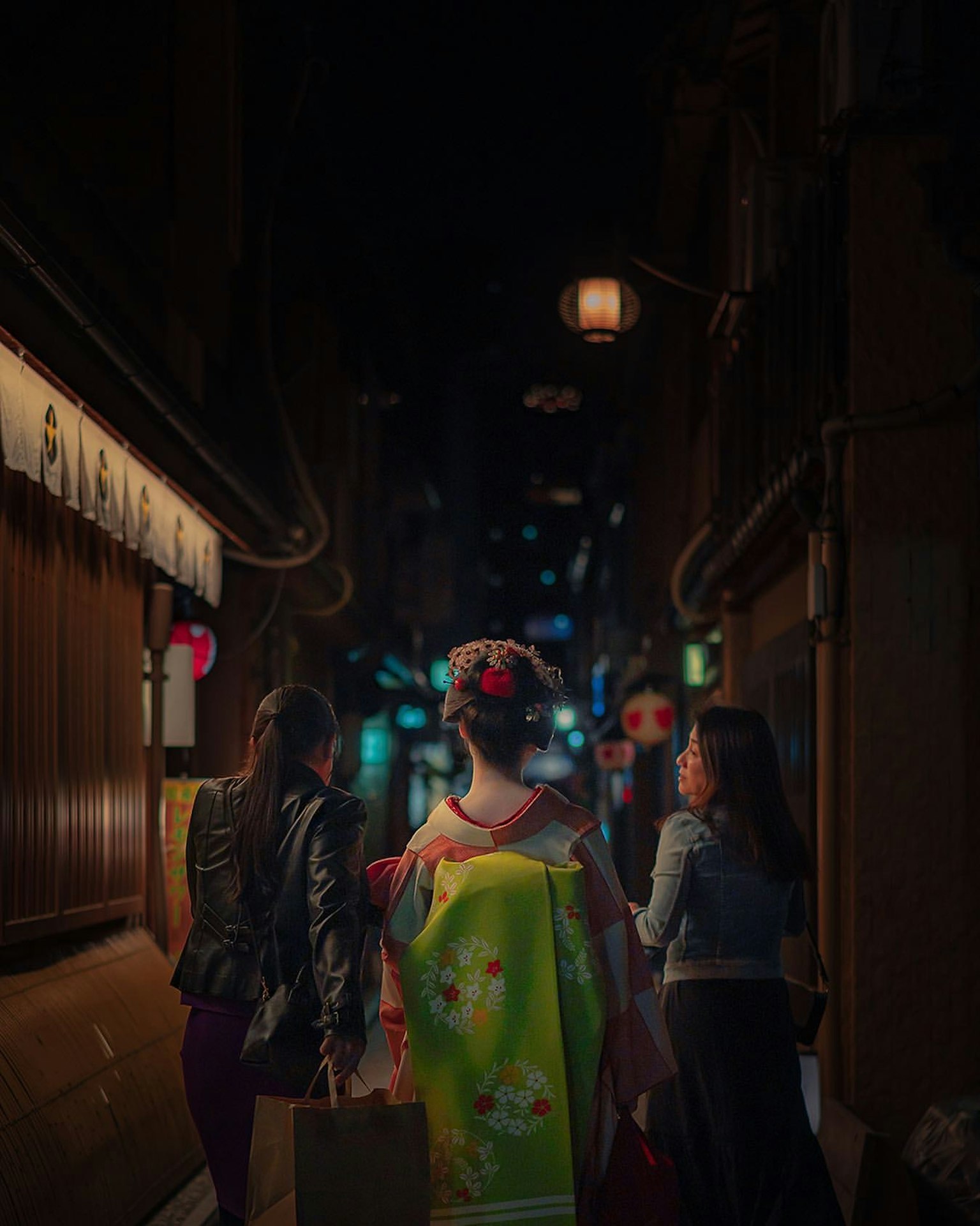 夜晚在狹窄街道上走的穿著美麗和服的女性