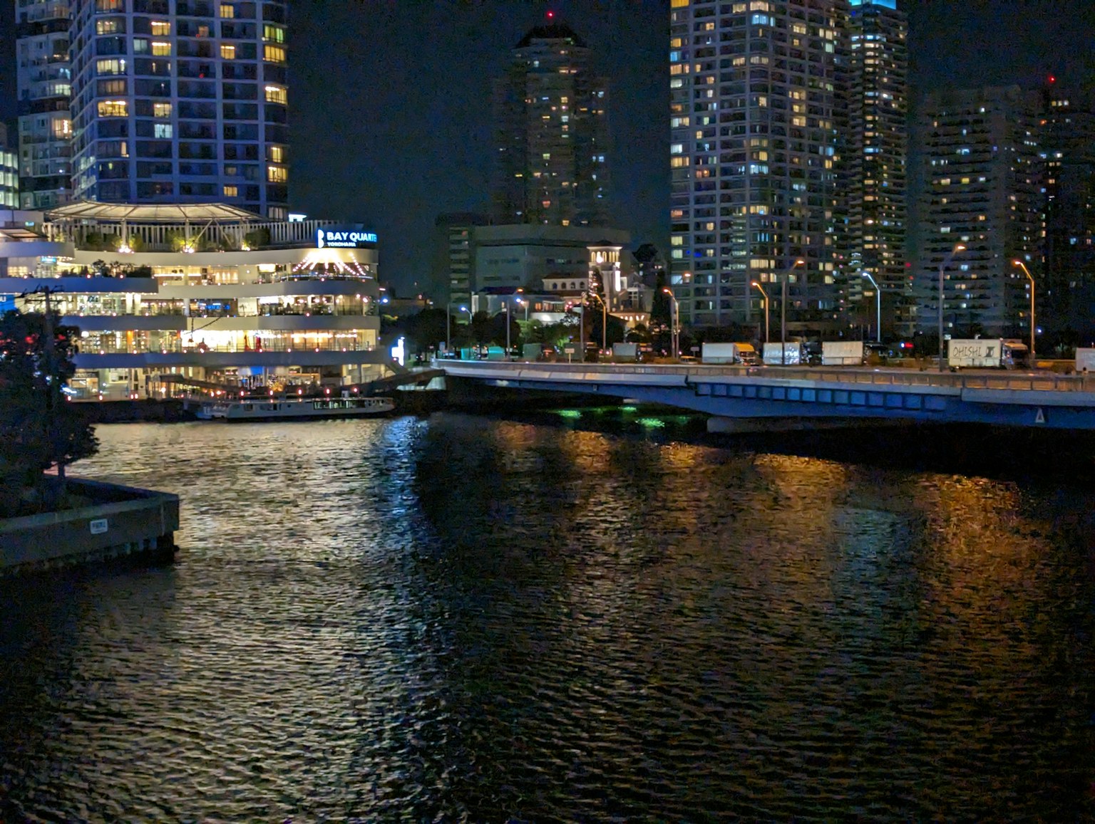 Pemandangan malam sungai dengan gedung pencakar langit yang diterangi