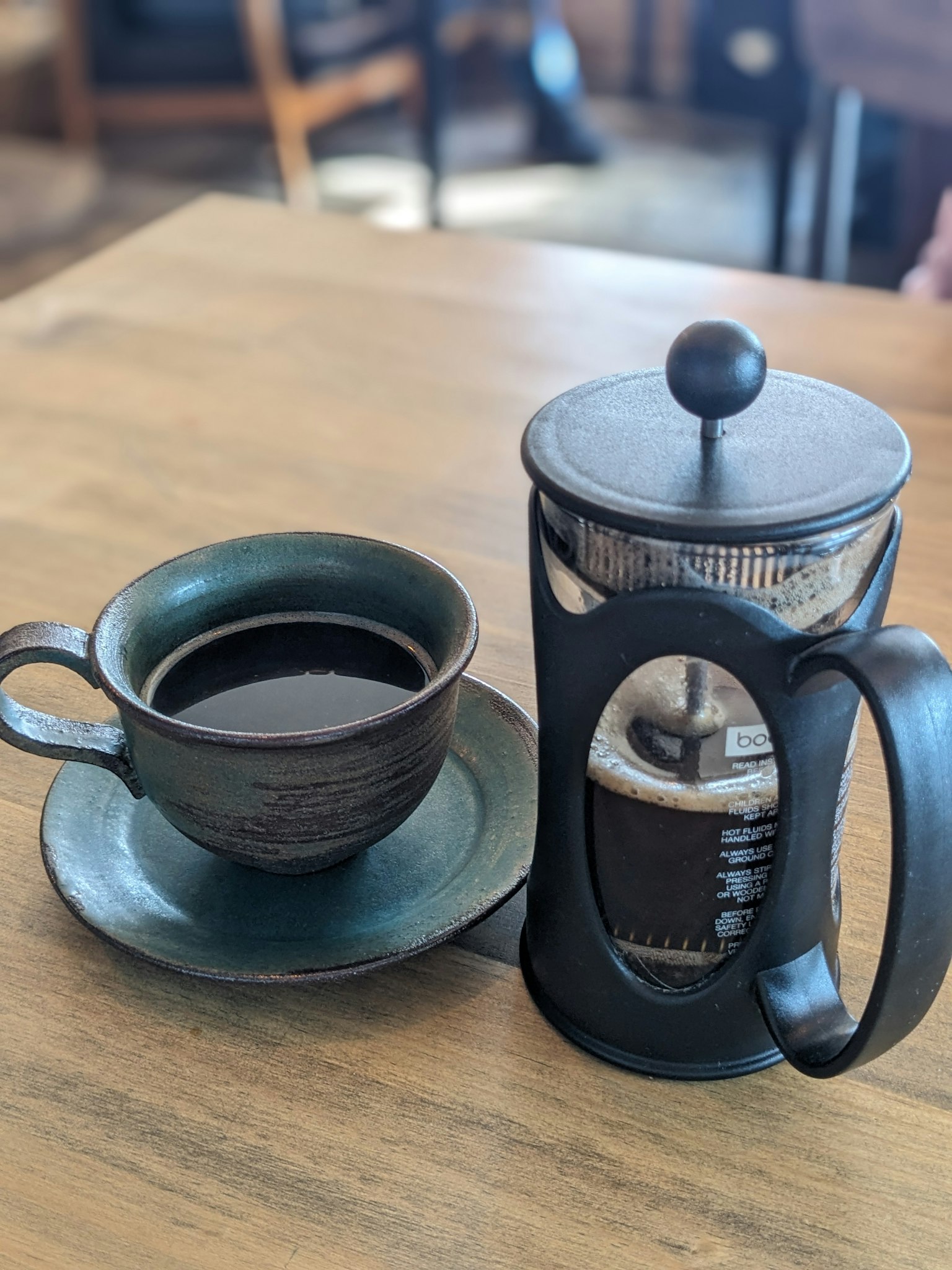 Pressa francese e tazza di caffè su un tavolo di legno