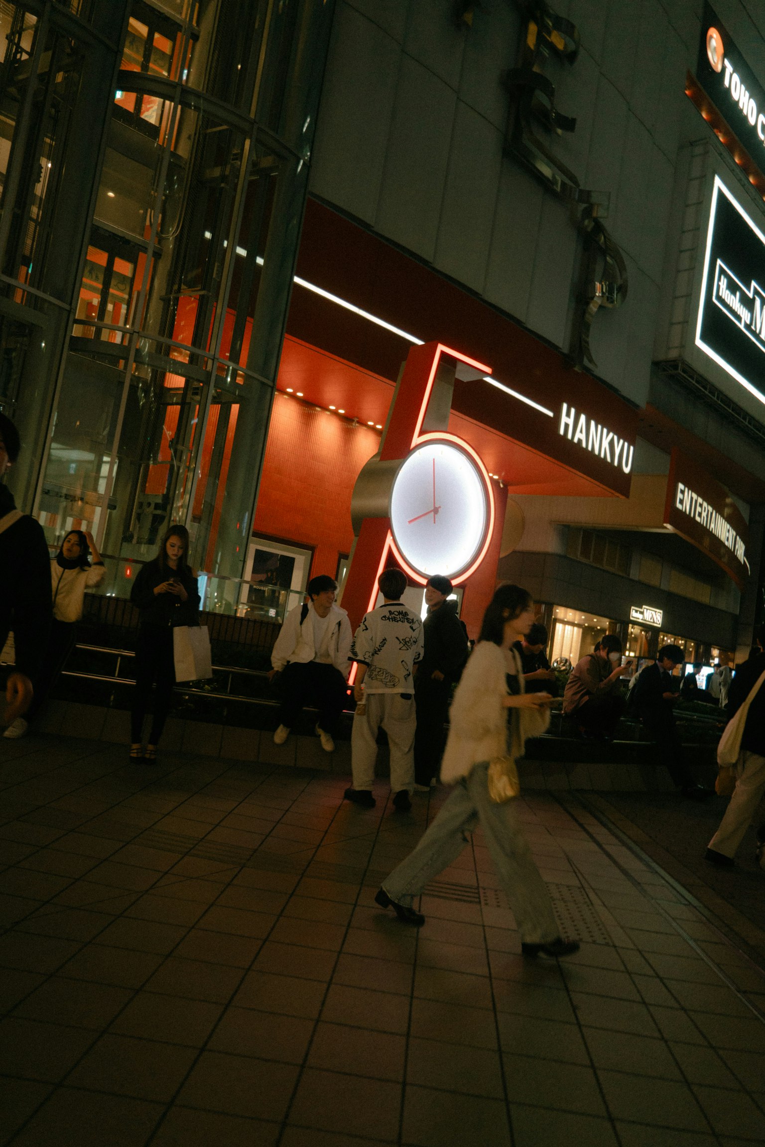 A vibrant street scene at night with pedestrians and striking lighting