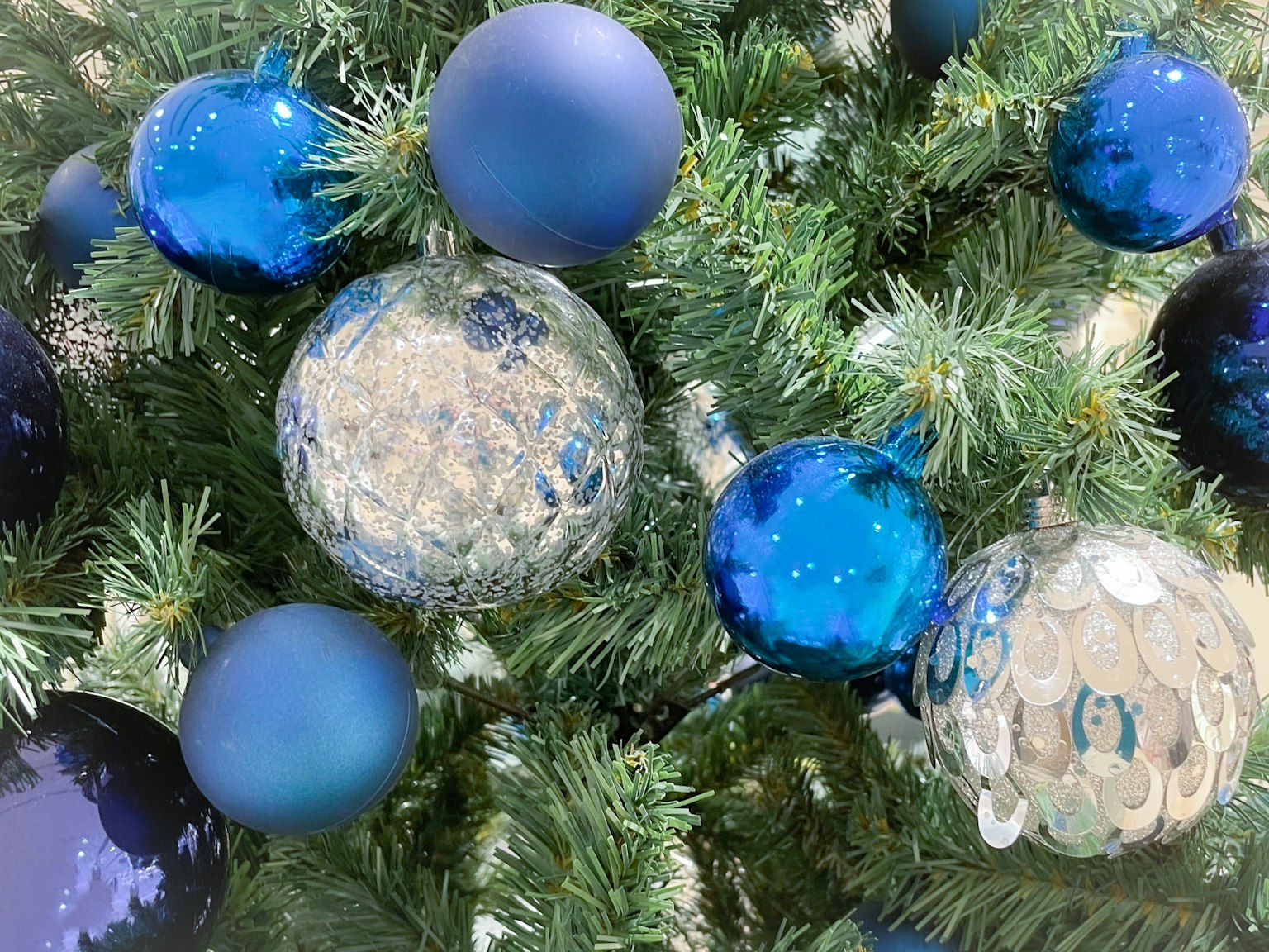 Cây thông Noel trang trí bằng đồ trang trí màu xanh và bạc