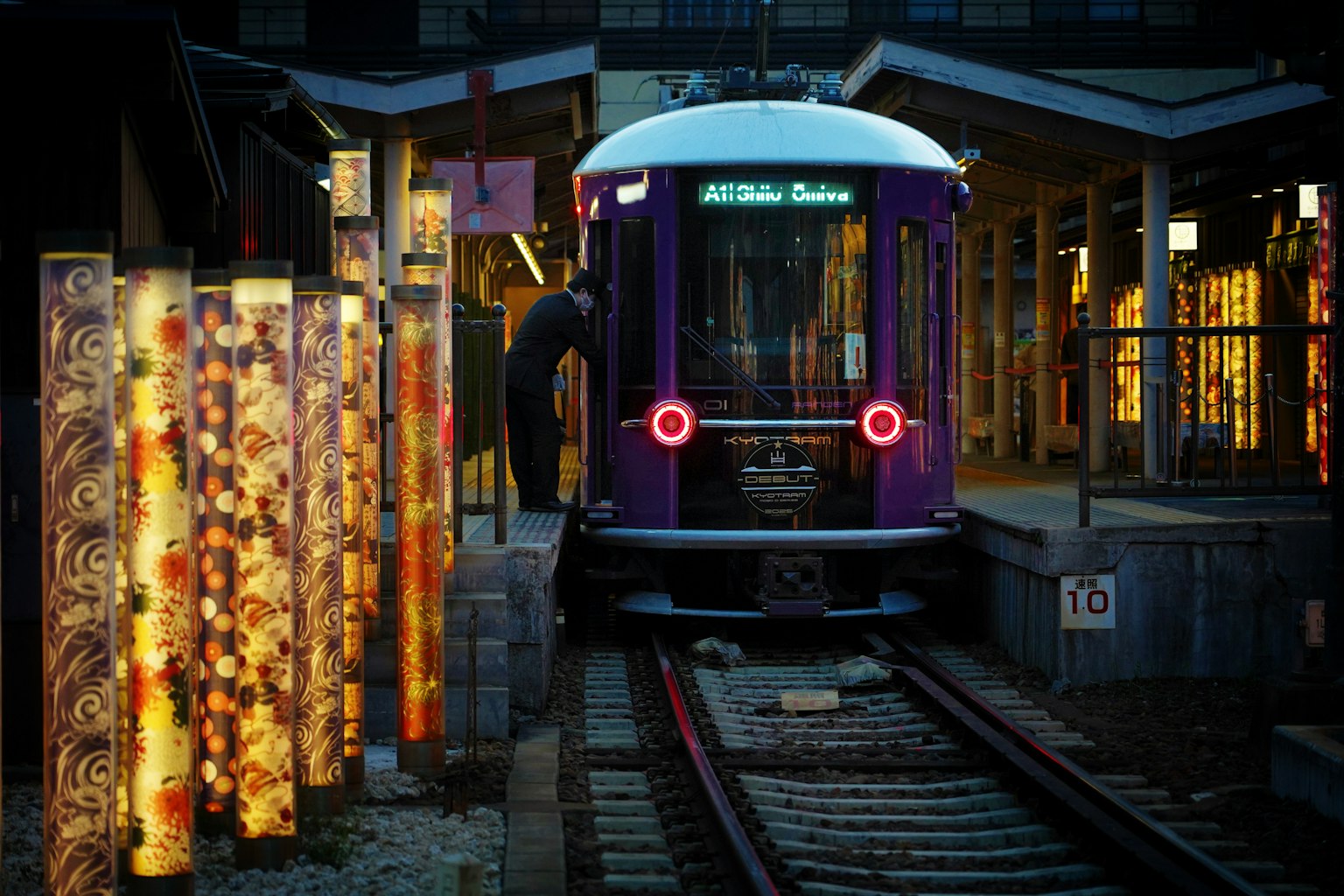 A purple train at a station surrounded by decorative lights and wooden structures