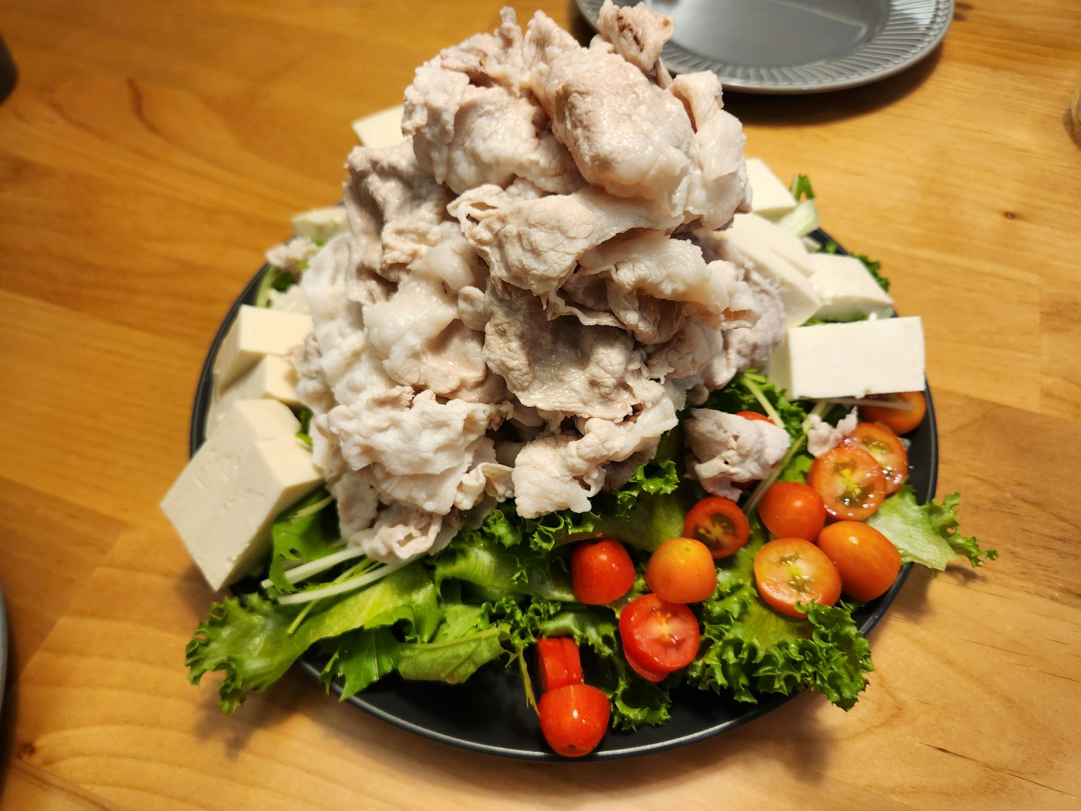 Hidangan dengan tumpukan ayam di atas sayuran dan tahu