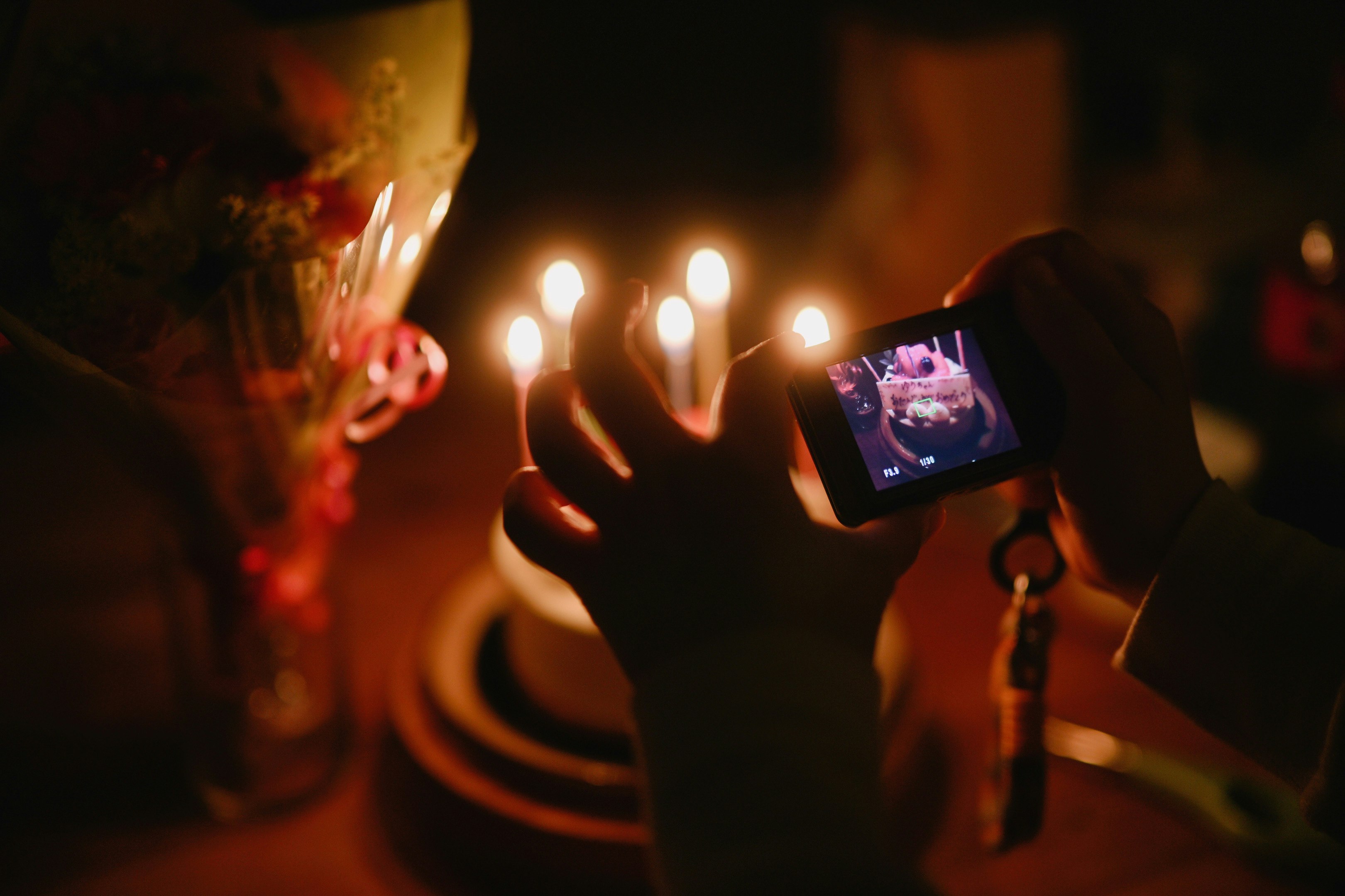 夜の街でスマホを掲げる人々のシーン