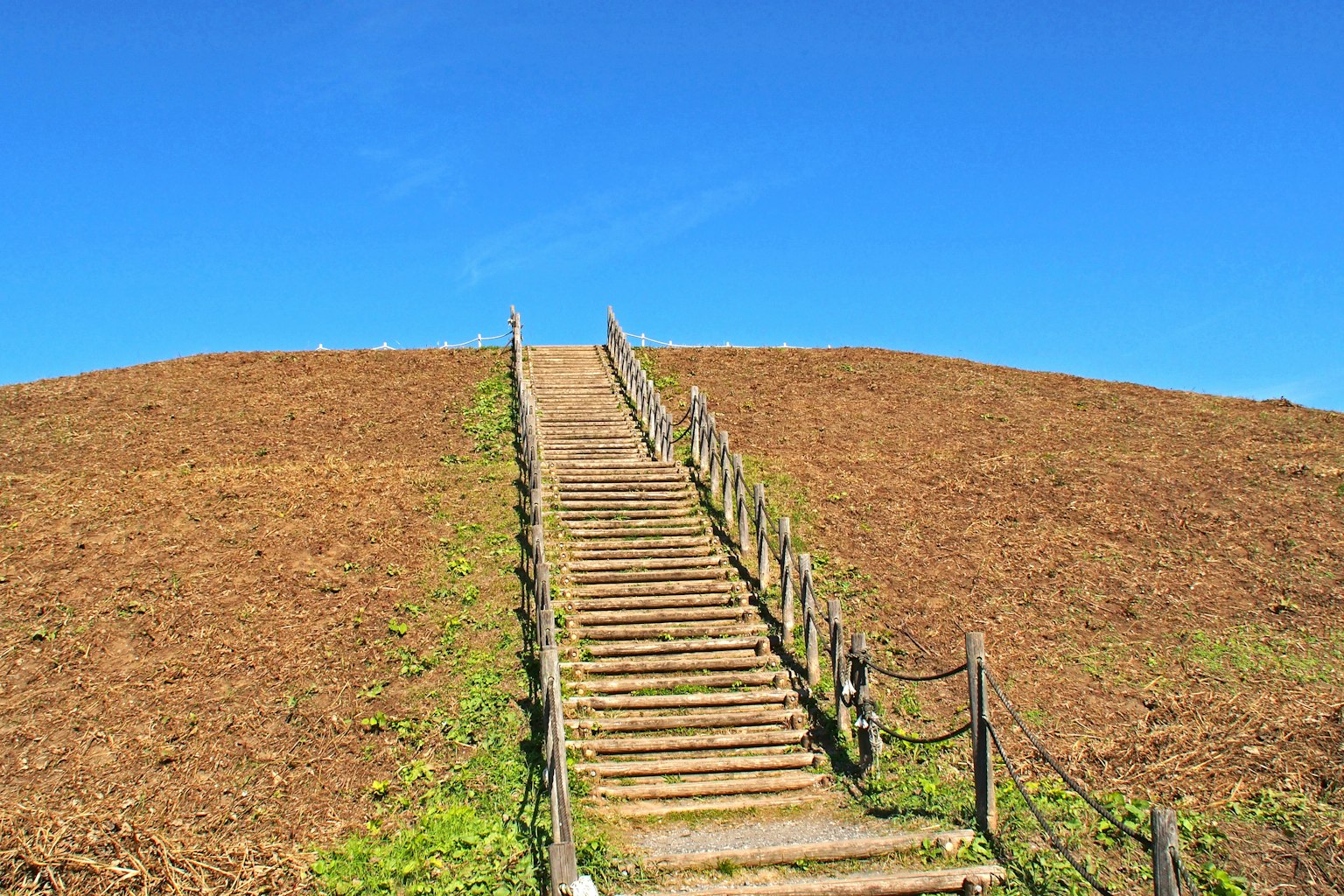Landschaft eines Hügels mit Treppen unter einem klaren blauen Himmel und trockenem Boden