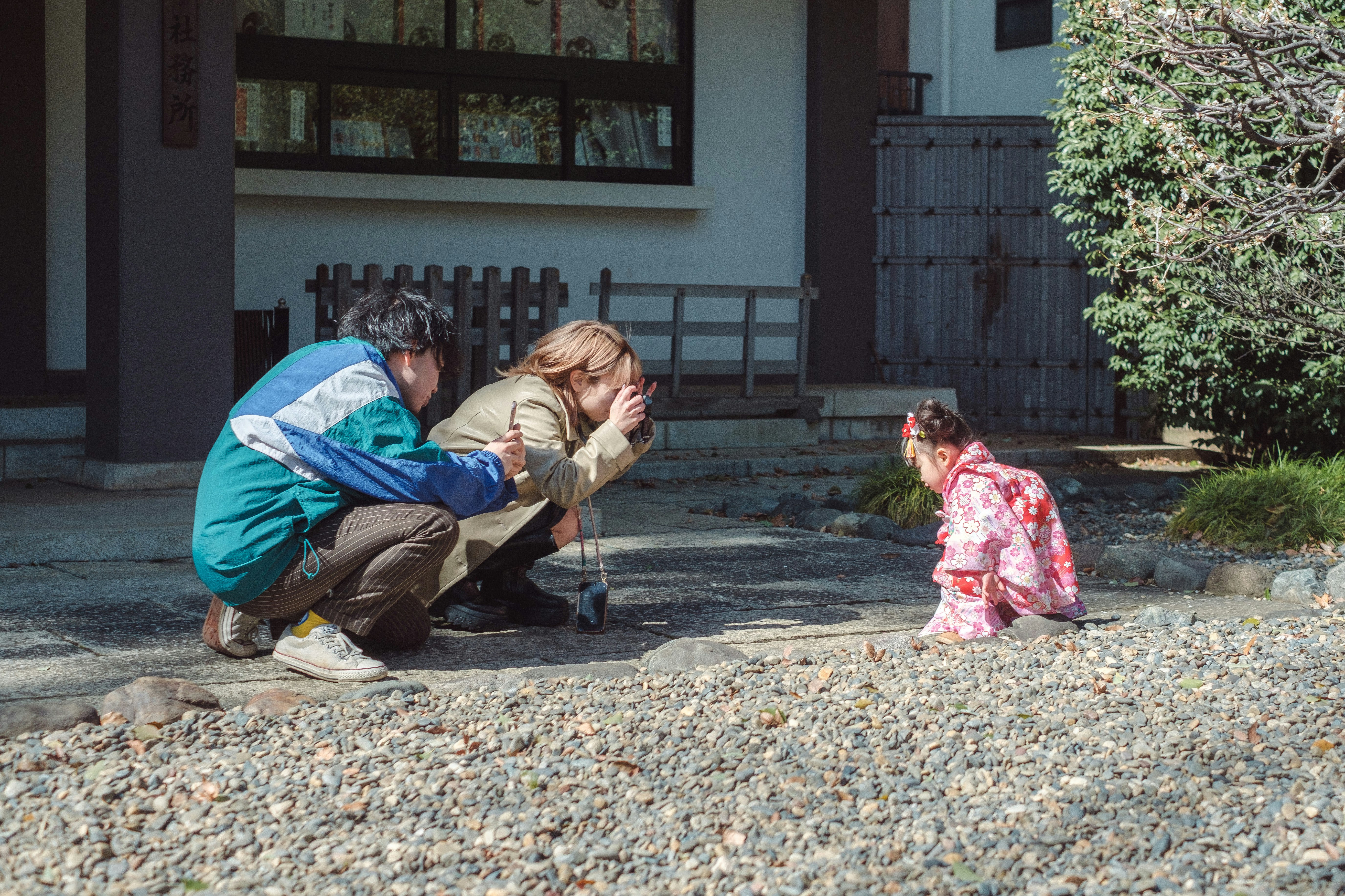 七五三の着物を着た子どもと家族が屋外で遊ぶ場面