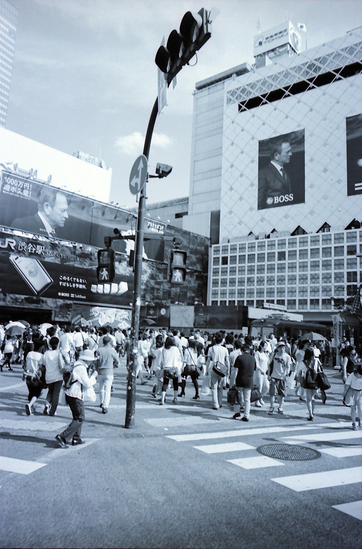 Black and white photo of people crossing Shibuya intersection
