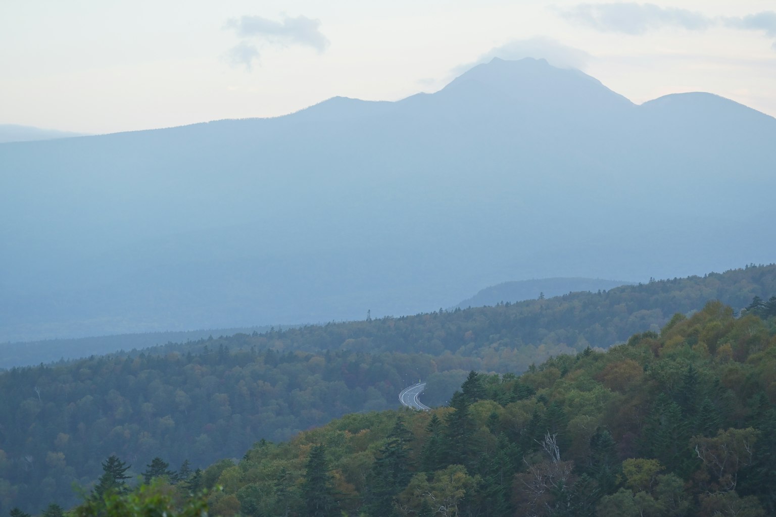 Montañas azules envueltas en niebla con árboles verdes en el valle