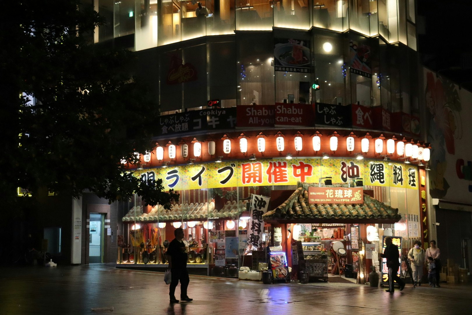 夜の国際通りで光る屋台と看板の並ぶ通りの風景