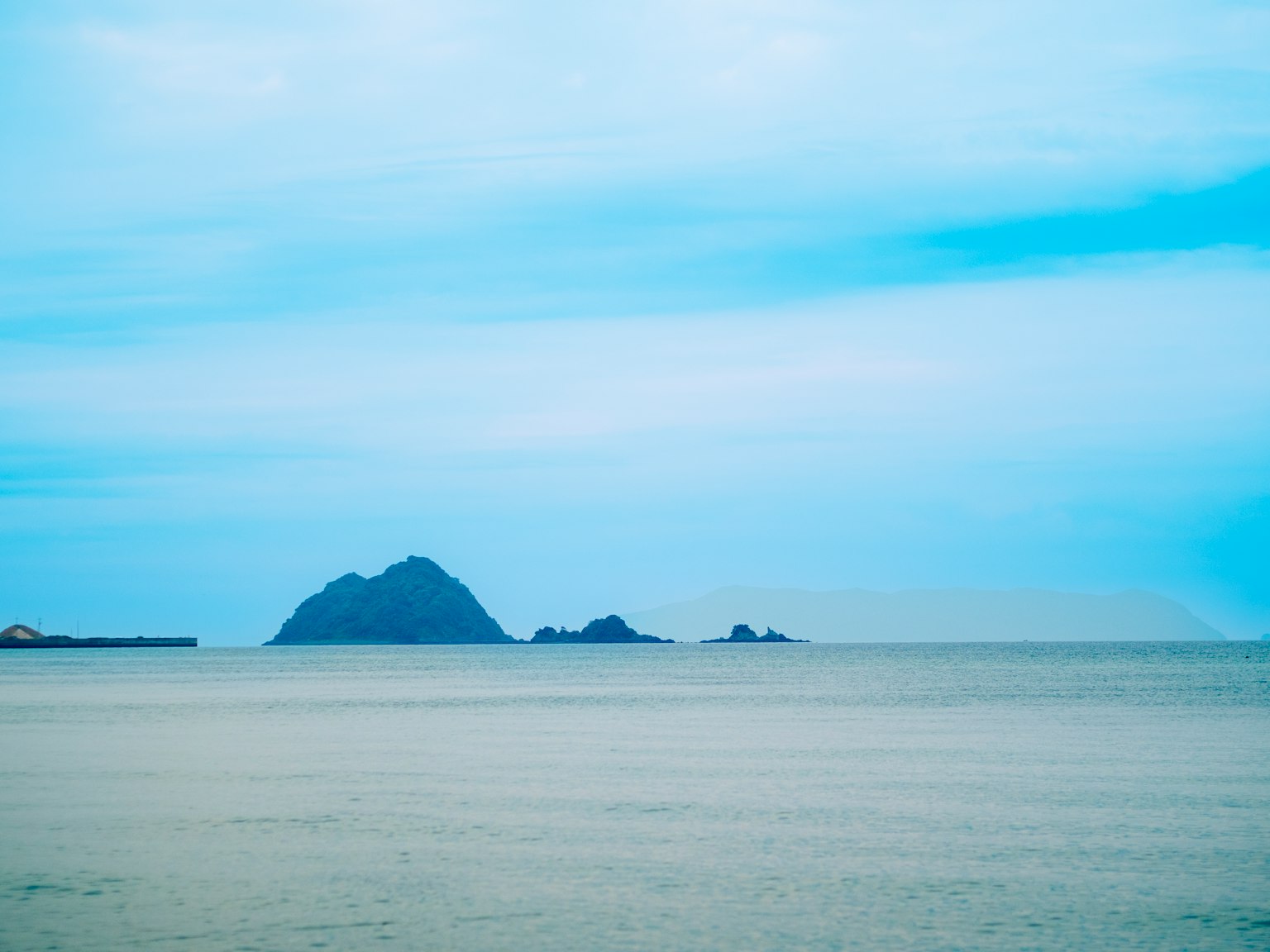 ทิวทัศน์ของเกาะในทะเลสงบใต้ท้องฟ้าสีฟ้า