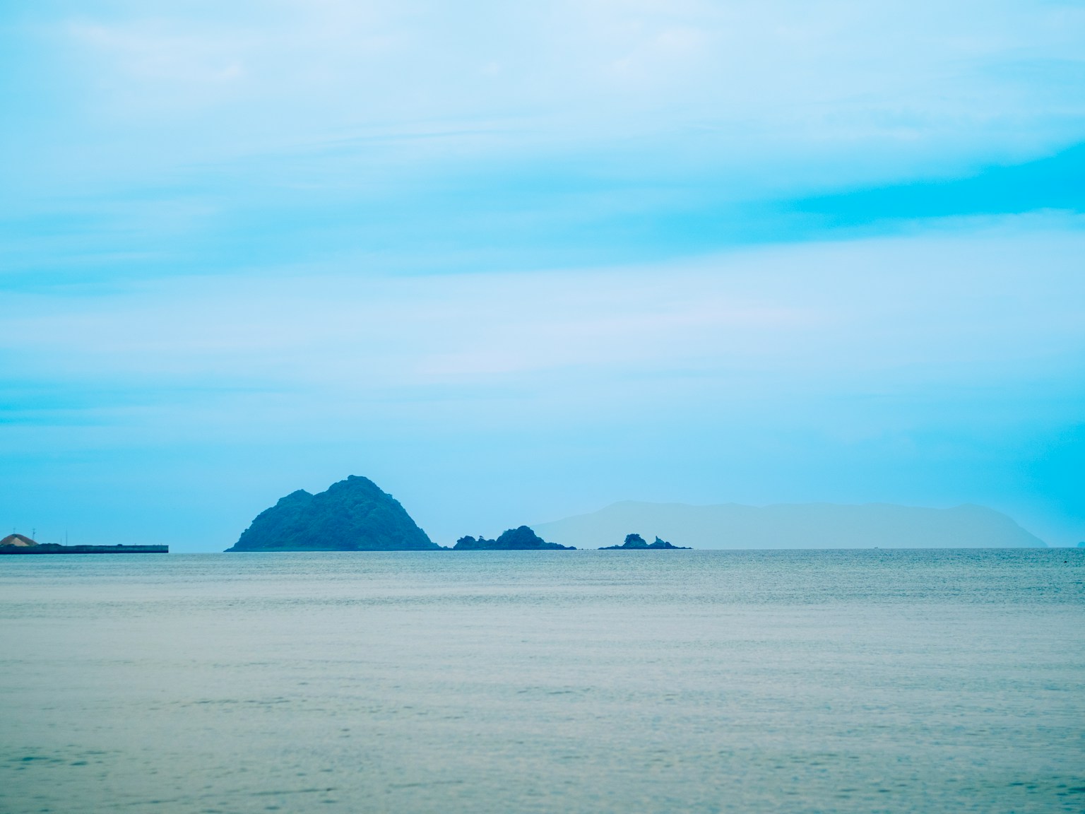View of islands on a calm sea under a blue sky