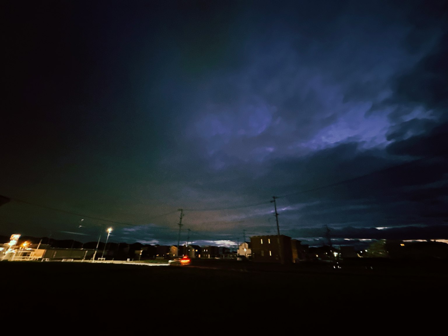 Nachthimmel mit Wolken und sichtbaren Stadtlichtern