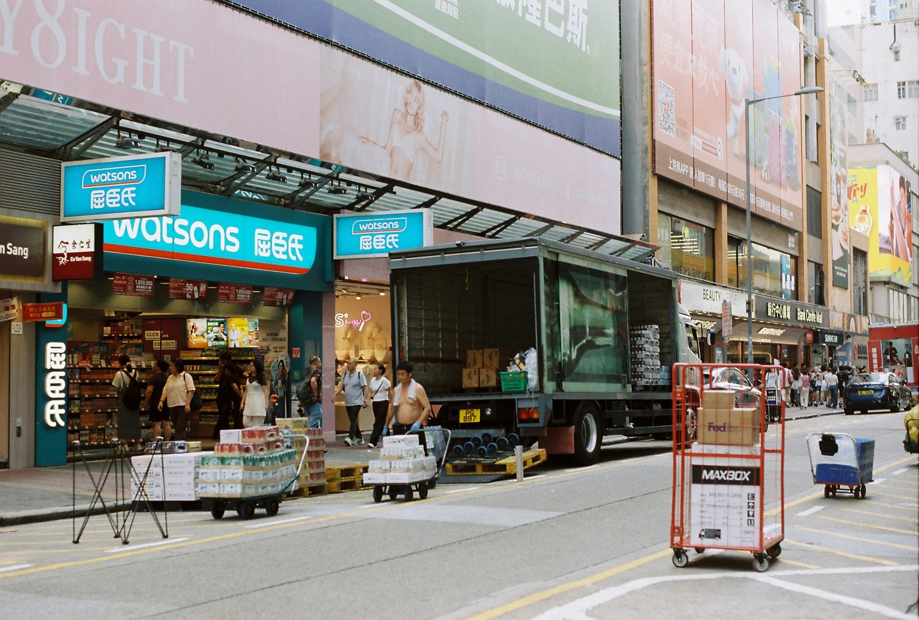 香港の街角で路上に並ぶトラックと店舗前の屋台