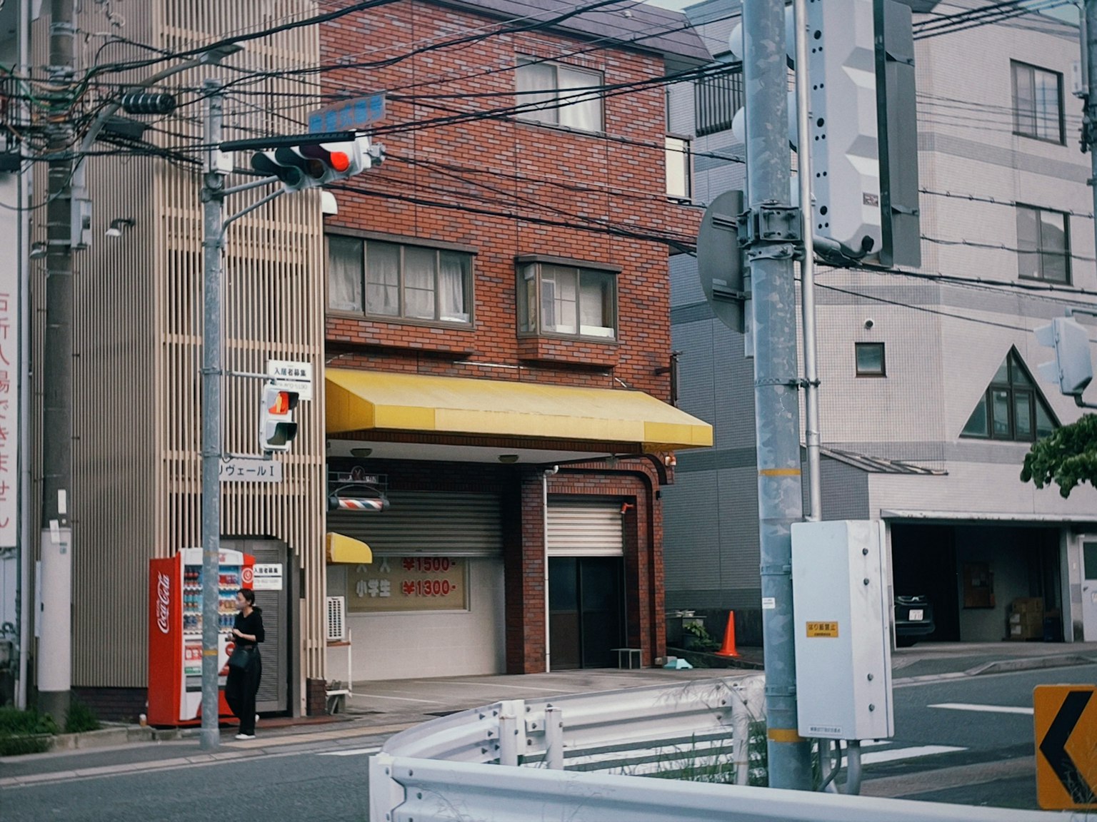 Street corner view featuring a brick building with a yellow awning