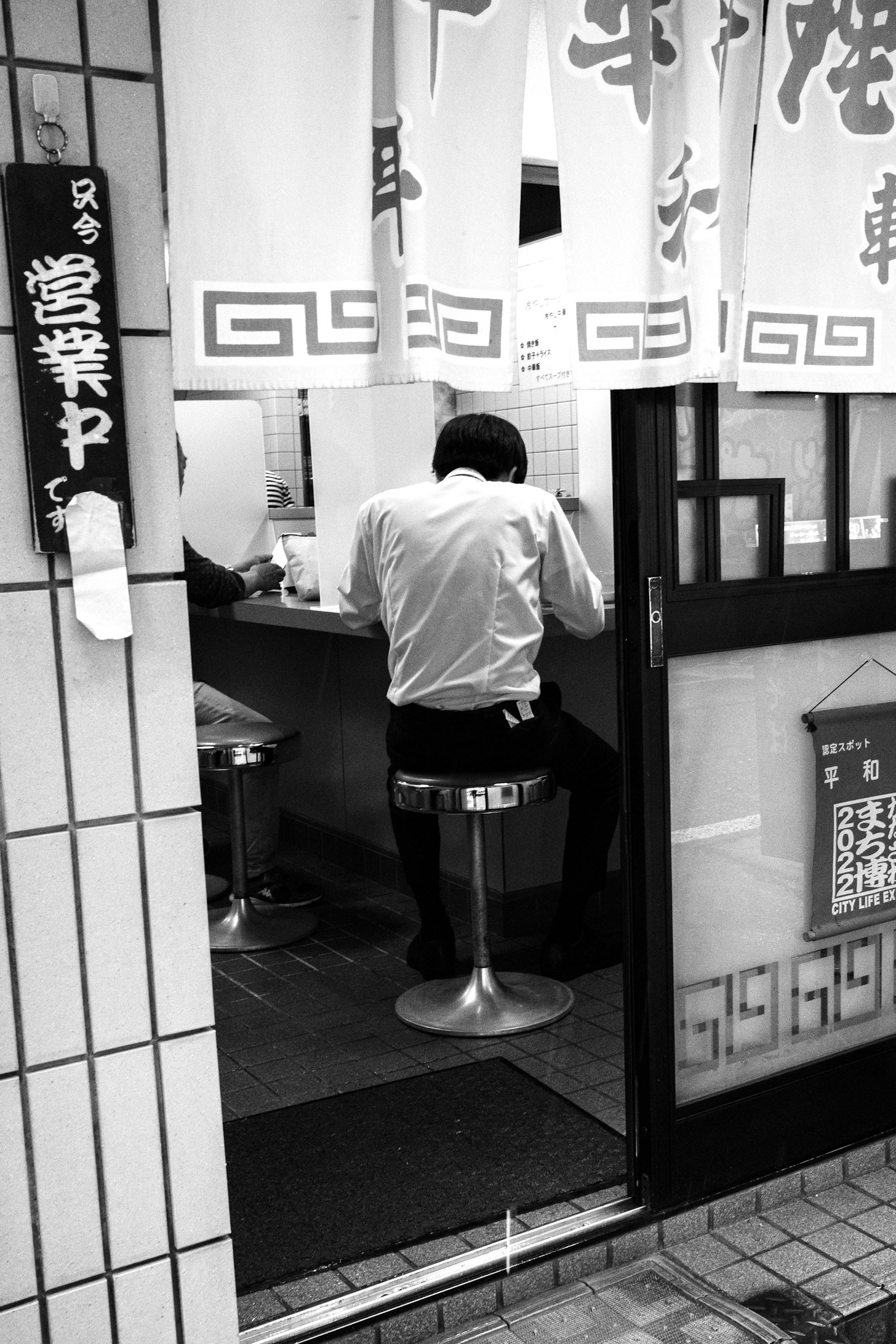 黑白照片中坐在櫃檯上的男人