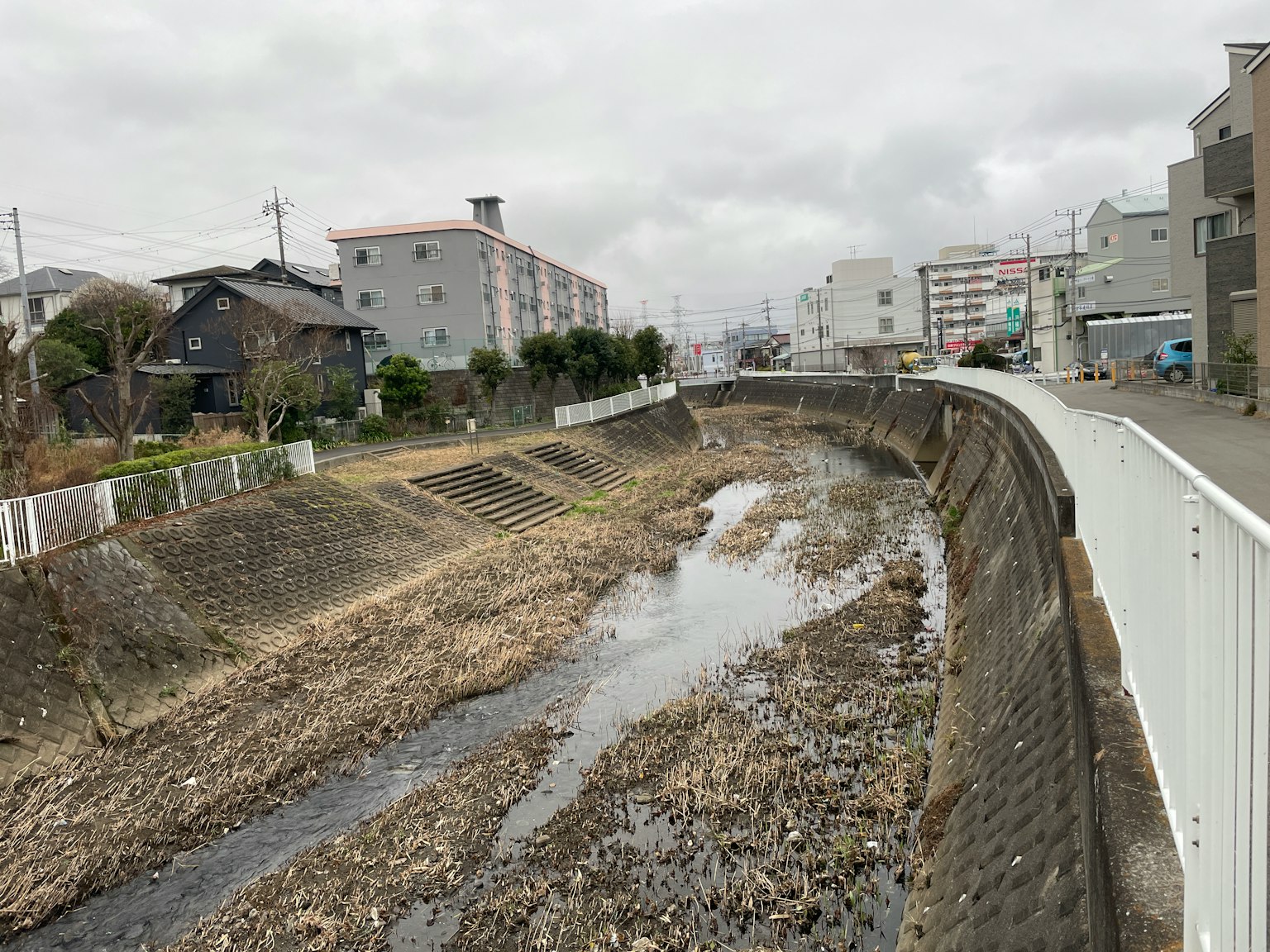 Un río estrecho con bajo nivel de agua y edificios circundantes