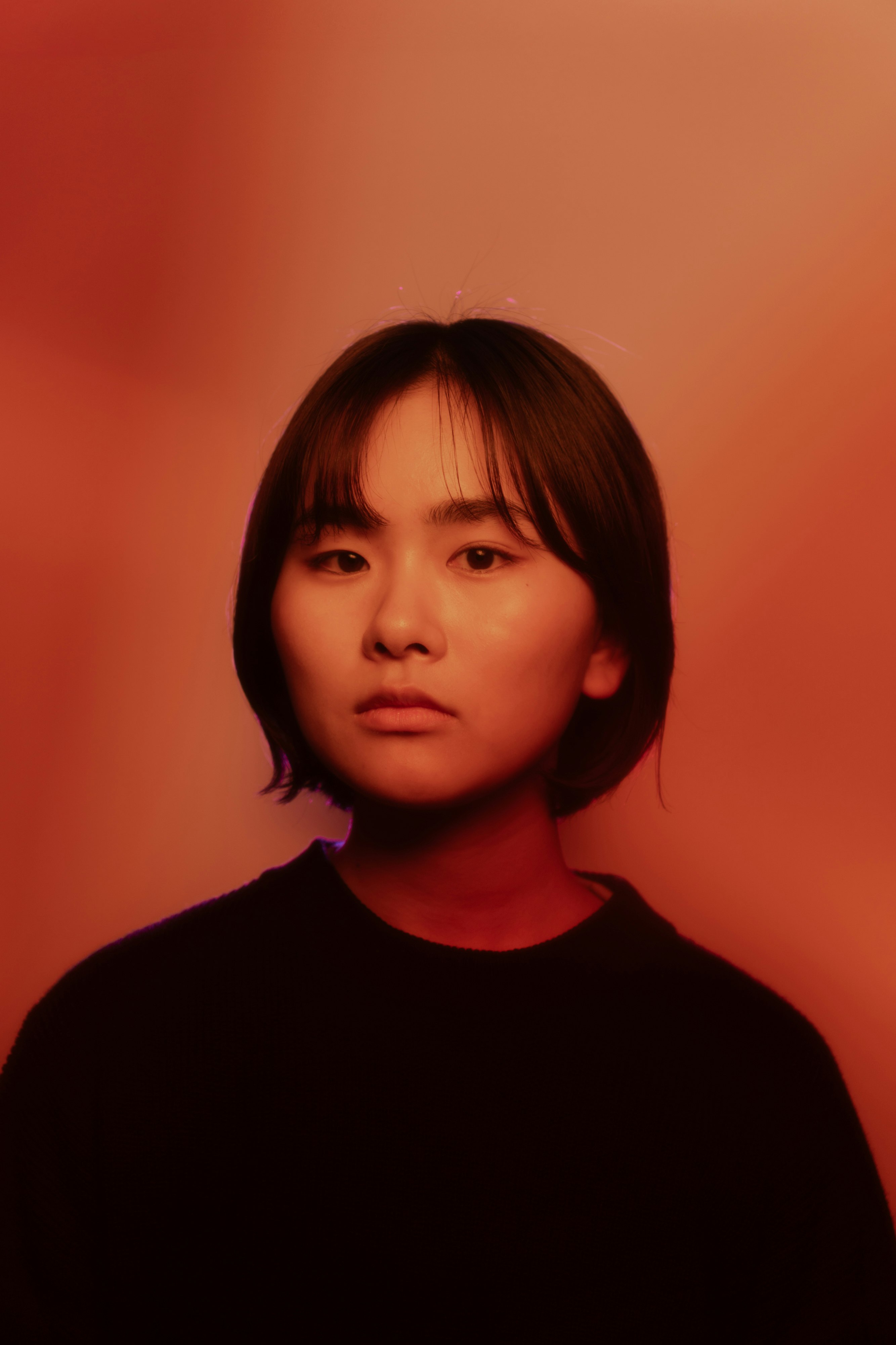 A person standing against a red background