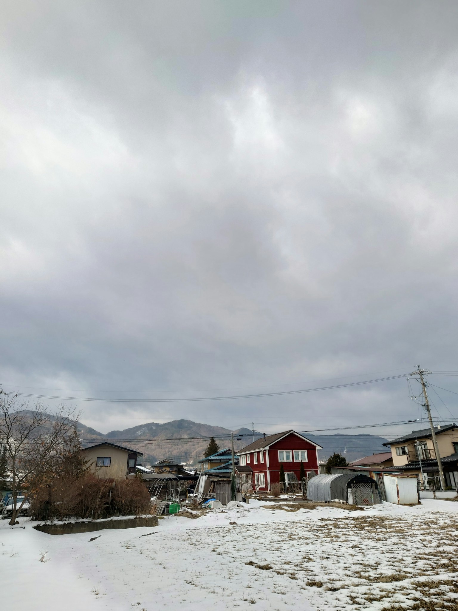 住宅区在阴云密布的天空下，地面被雪覆盖