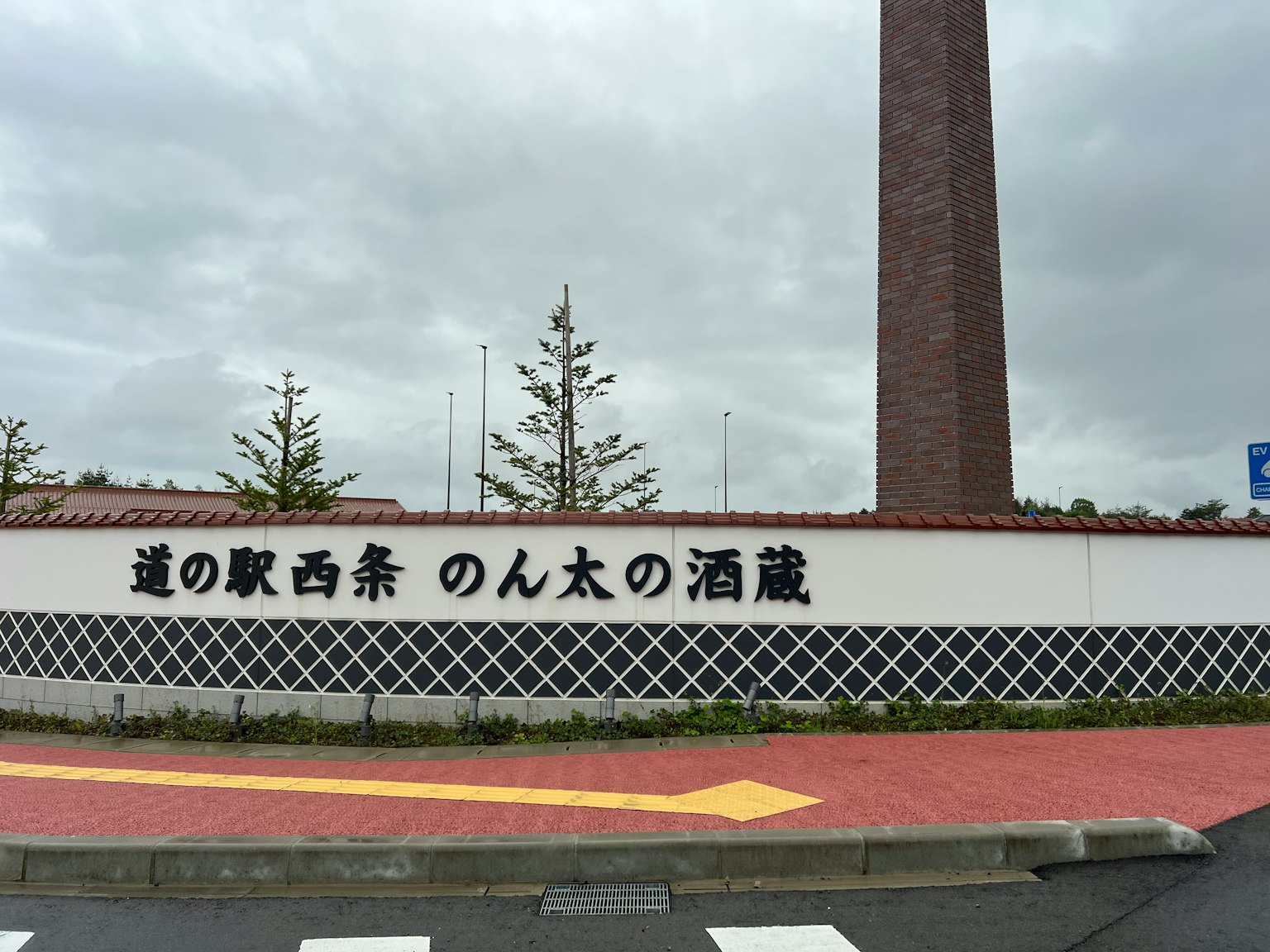 Schild der Straßenstation Saijo Nontan Sake Brewery mit einem Schornstein