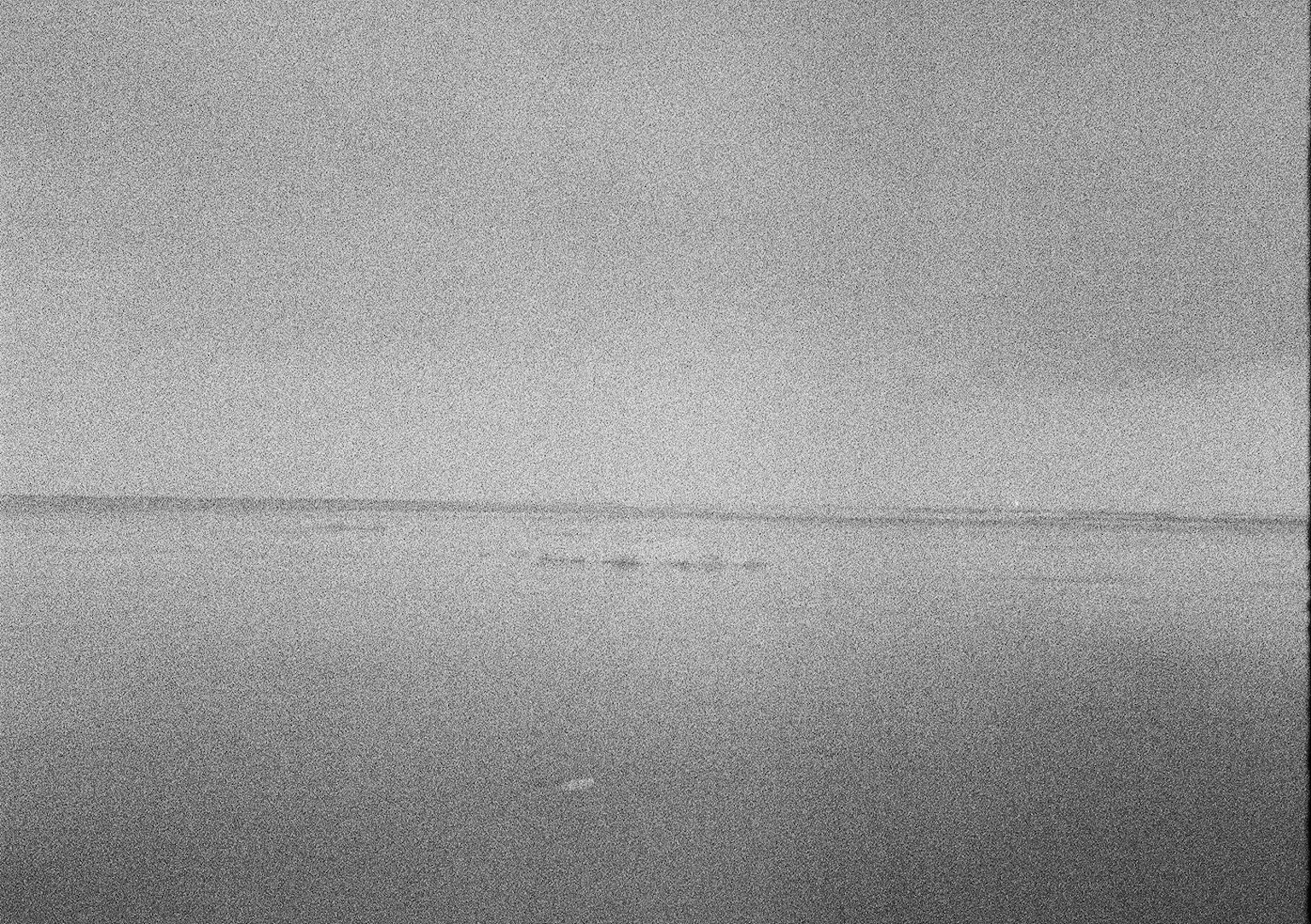 Paysage maritime en noir et blanc avec un horizon et une surface d'eau calme