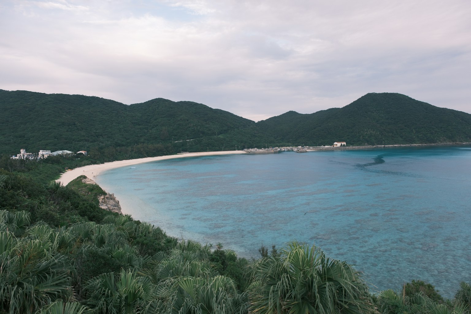 Panoramablick auf einen Strand mit Bergen und klarem Wasser
