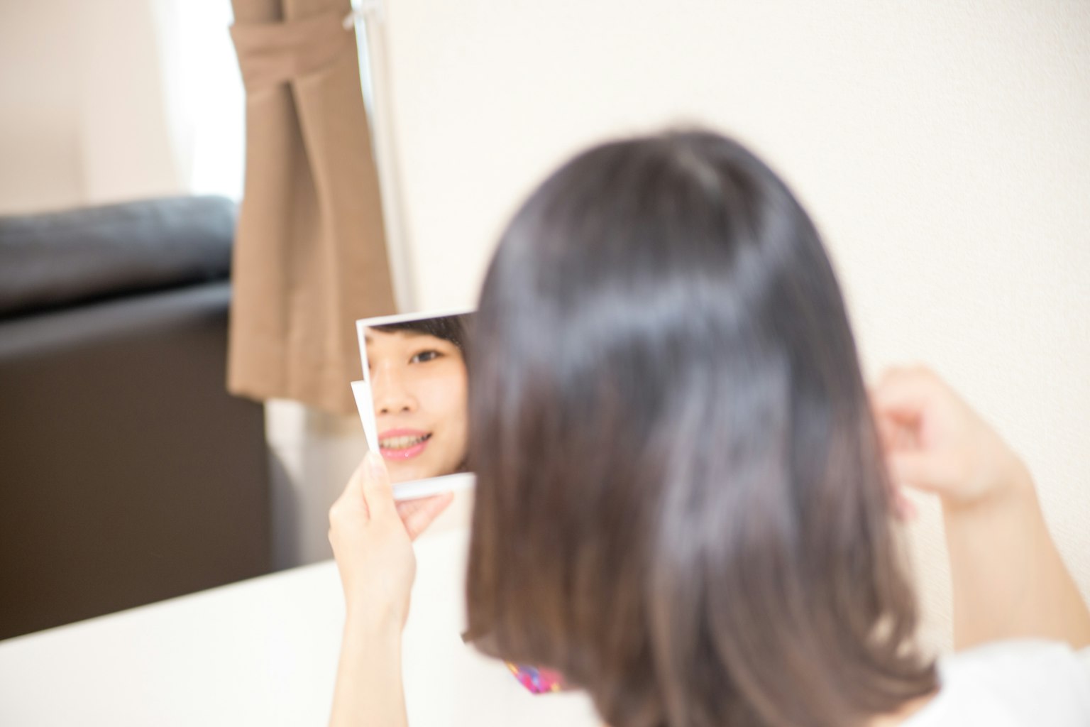 Femme regardant dans un miroir avec un petit reflet souriant