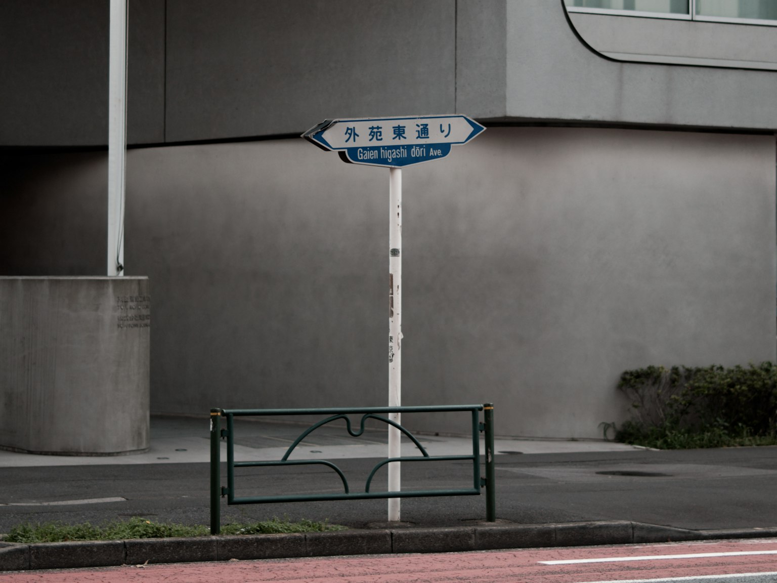 Blaues Straßenschild an einer Straßenecke mit umliegenden Gebäuden